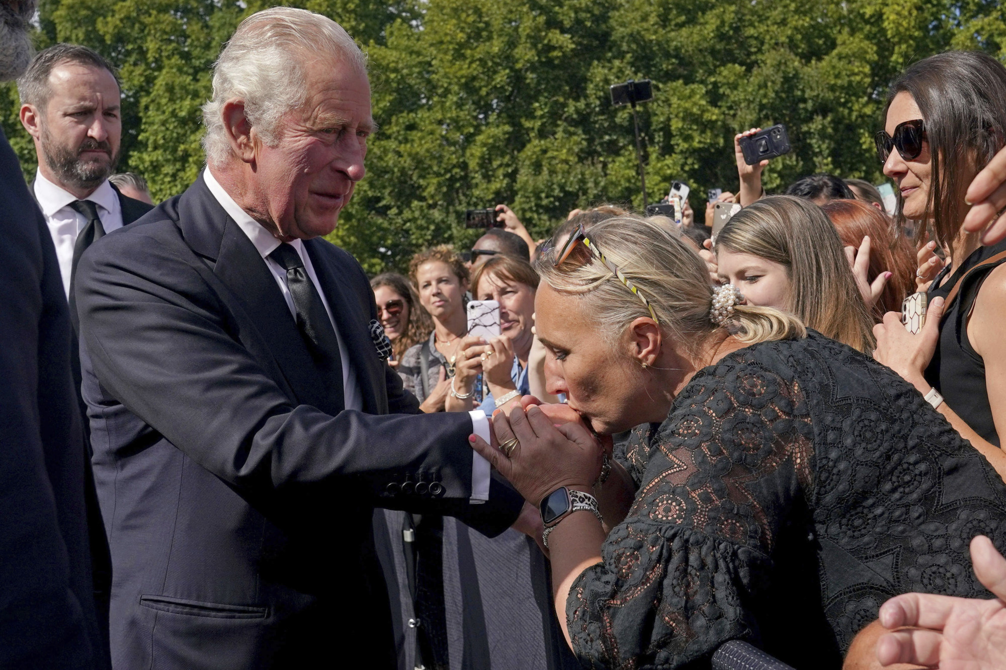 A well-wisher kisses the hand of King Charles outside Buckingham Palace. Photo: AP