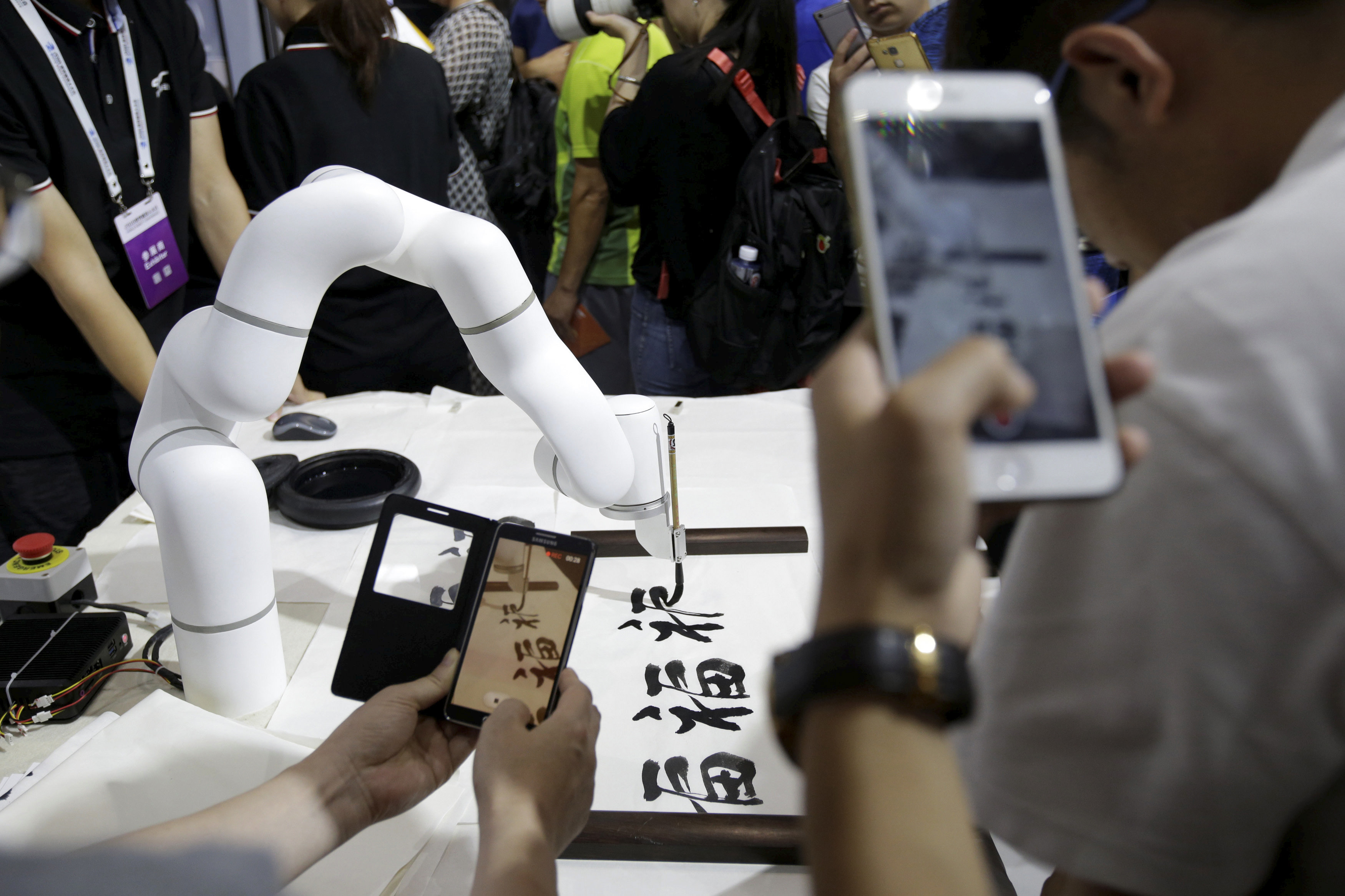 A robotic arm writes Chinese calligraphy at Cheetah Mobile’s booth at the World Robot Conference (WRC) in Beijing. Photo: Reuters 