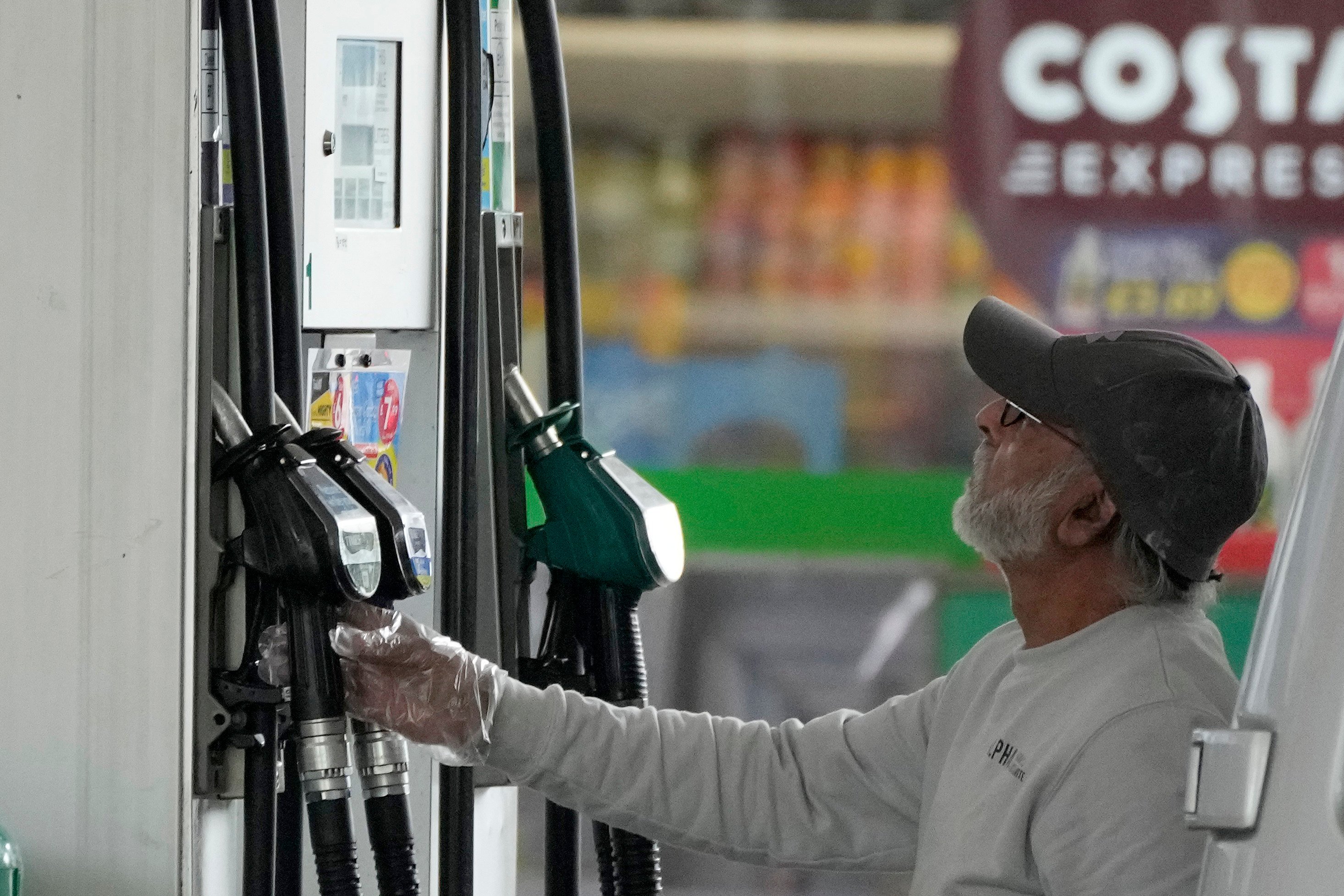 A motorist checks a petrol pump at a filling station in London, on June 9. Britain’s new Prime Minister Liz Truss has pledged to rebuild an ailing economy, on the brink of a potentially long recession, with record inflation and millions in need of government help to cope with energy bills. Photo: AP