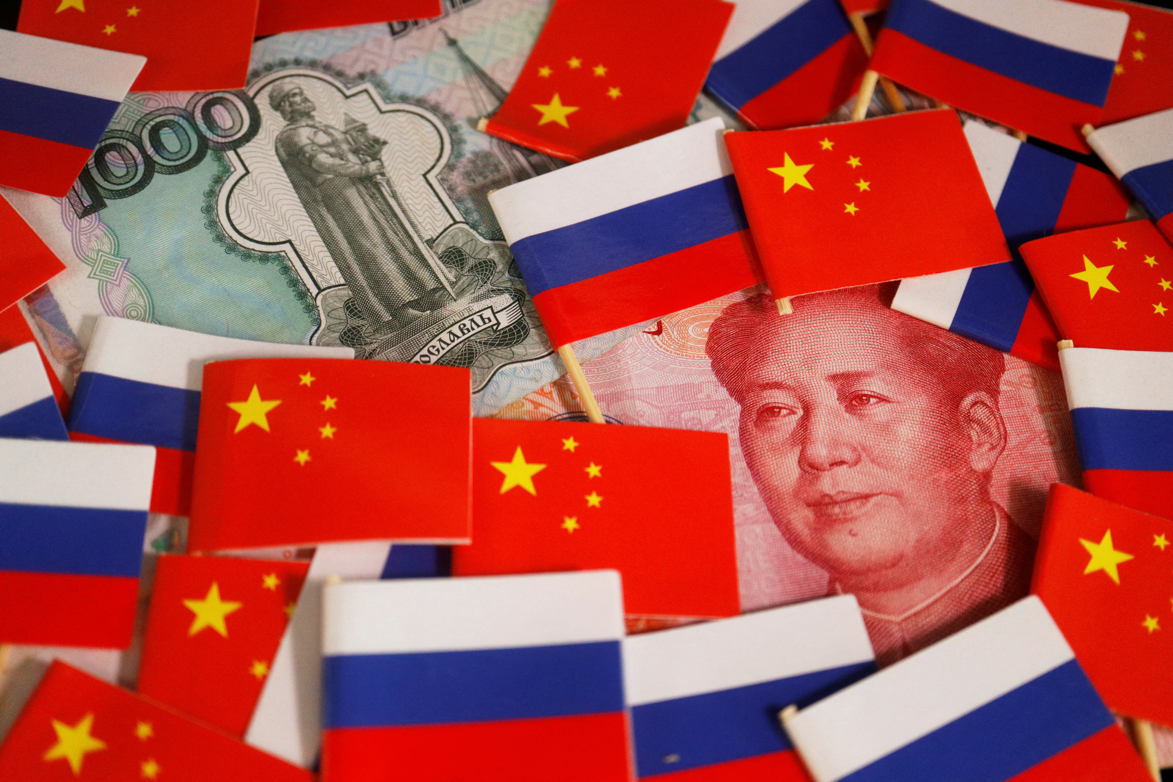 Chinese yuan and Russian rouble banknotes are seen surrounded by the national flags of China and Russia. Photo: Reuters