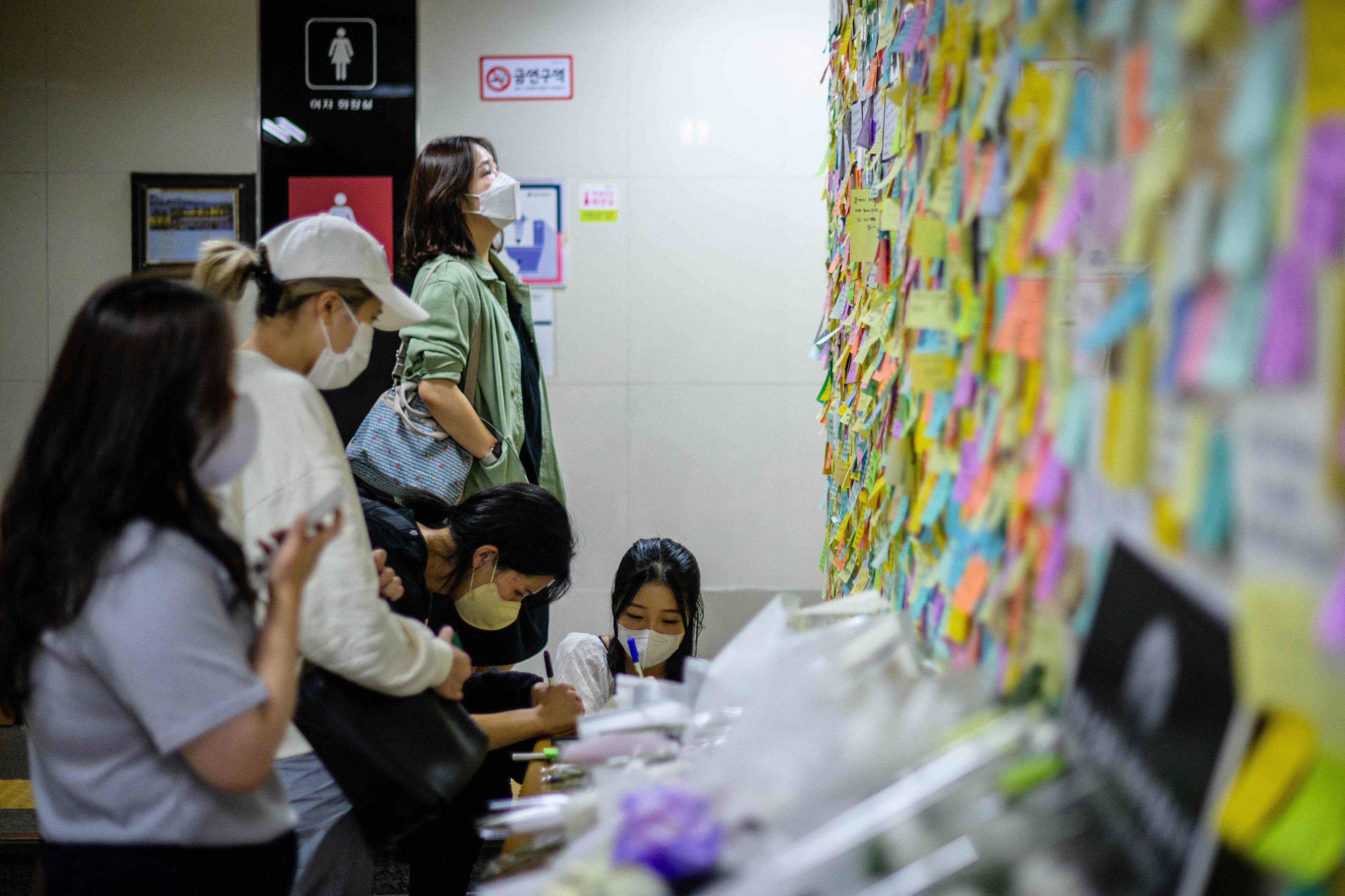 Women mourn the death of a woman killed by her stalker, outside the women’s toilet in Seoul’s Sindang Station, on September 19. Photo: AFP