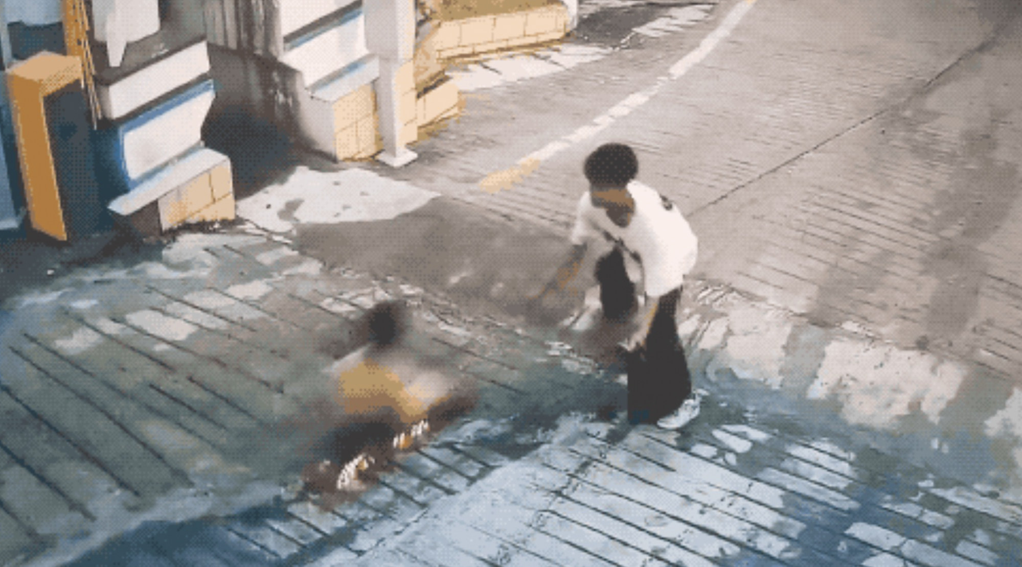 An image catches the moment when a teenager preventing the child from rolling into traffic on a scooter. Photo: Youth.cn