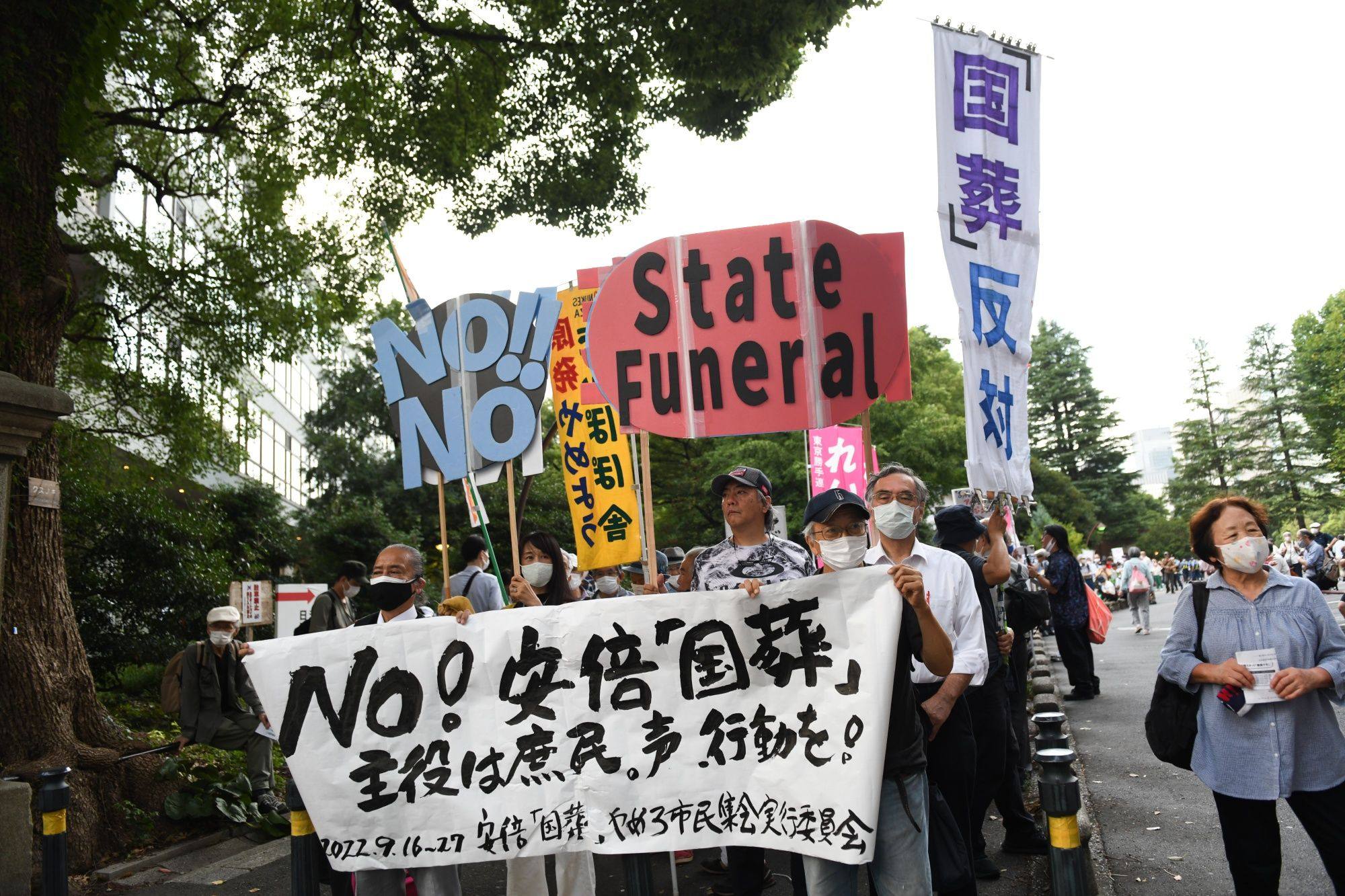Demonstrators hold placards during a protest against the planned state funeral for slain former Japanese prime minister Shinzo Abe in Tokyo last week. Photo: Bloomberg