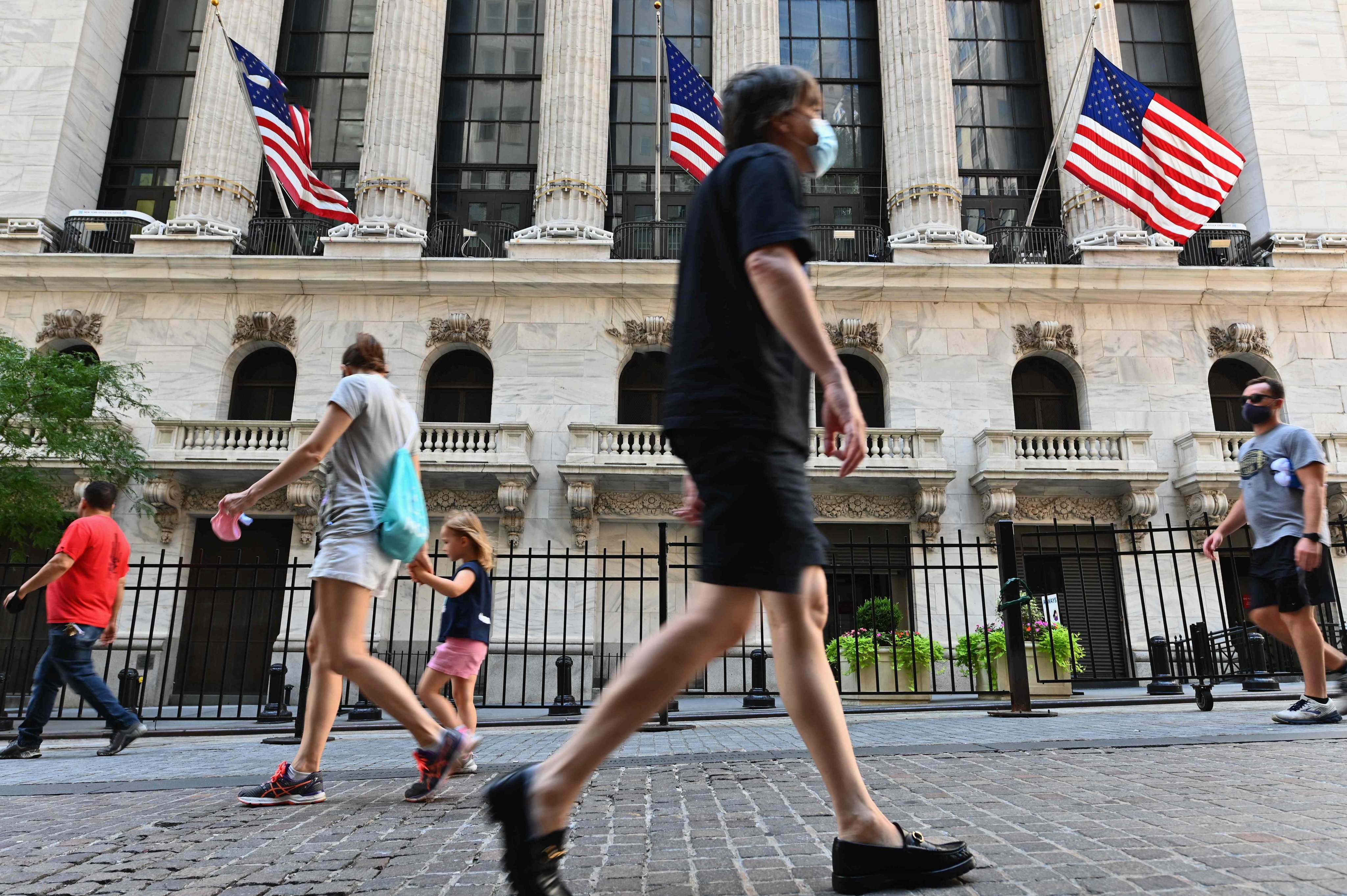 People pass by The New York Stock Exchange (NYSE) at Wall Street in New York City in August 2020. Photo: AFP