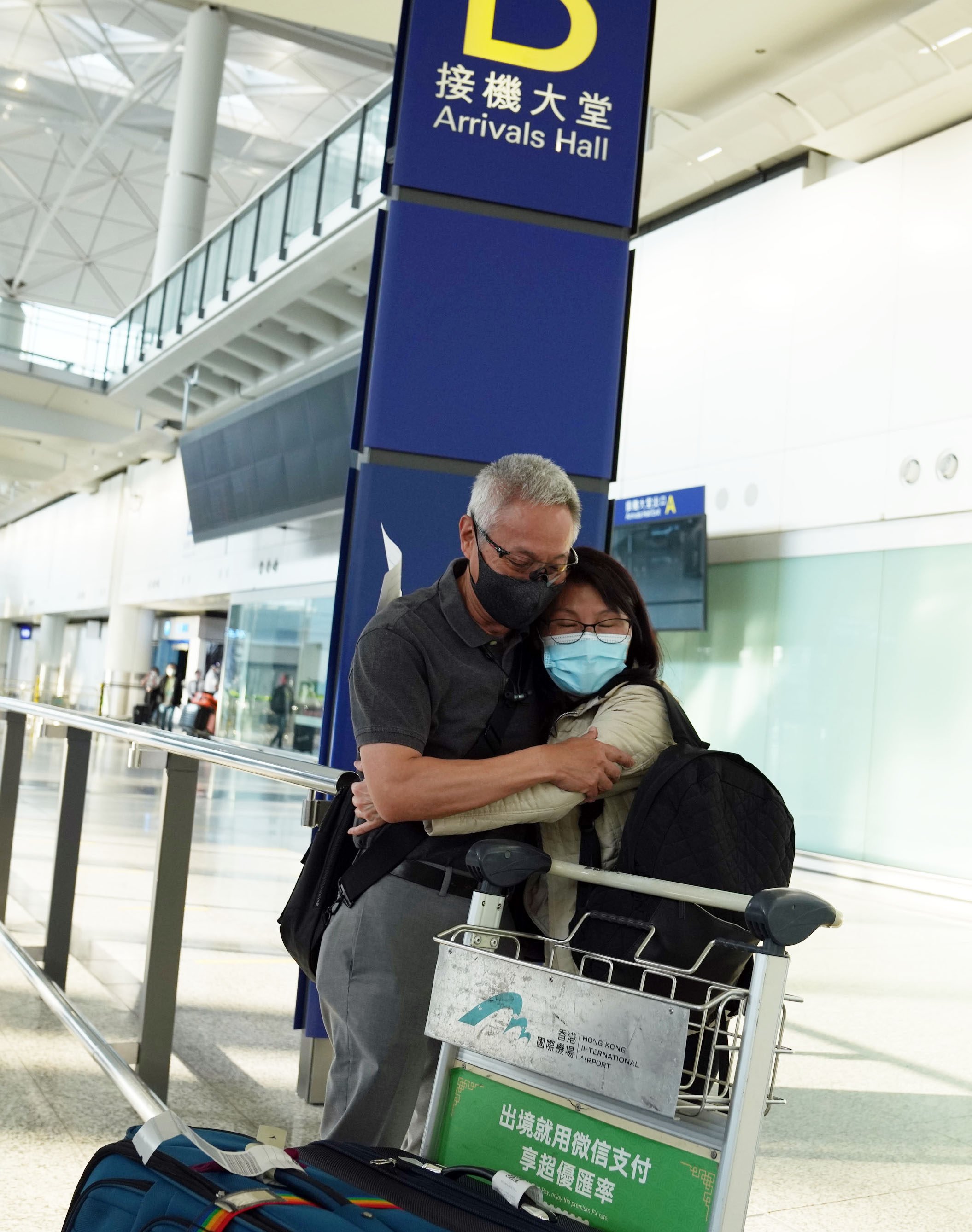 A traveller hugs a loved one after being among the first in Hong Kong to arrive without having to serve quarantine. Photo: Sam Tsang