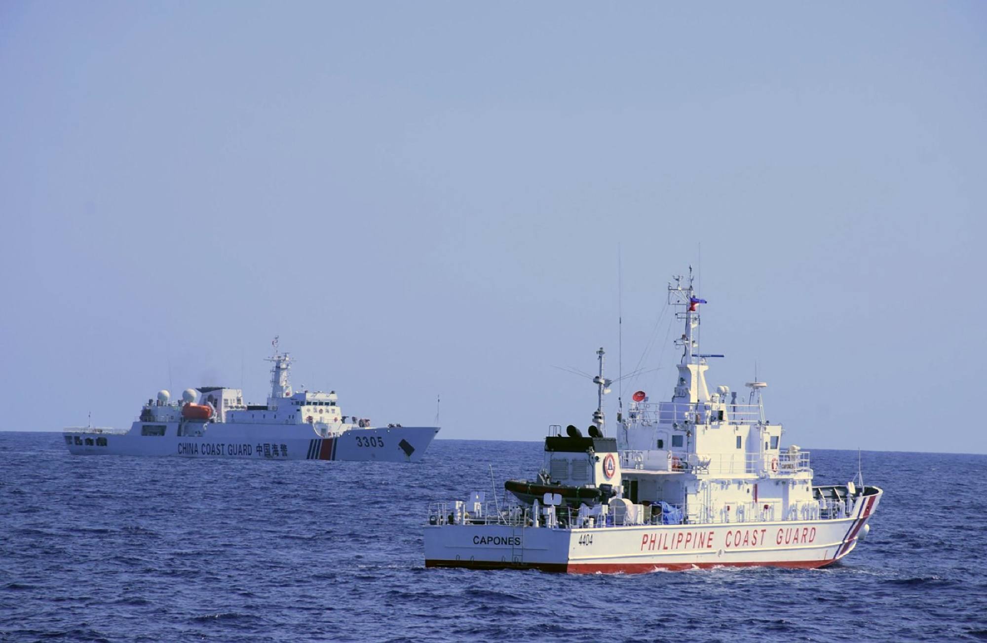 A Chinese coastguard ship (left) shadows a Philippine coastguard vessel while patrolling the Scarborough Shoal in the South China Sea, on March 2. Photo: AFP/Philippine Coast Guard