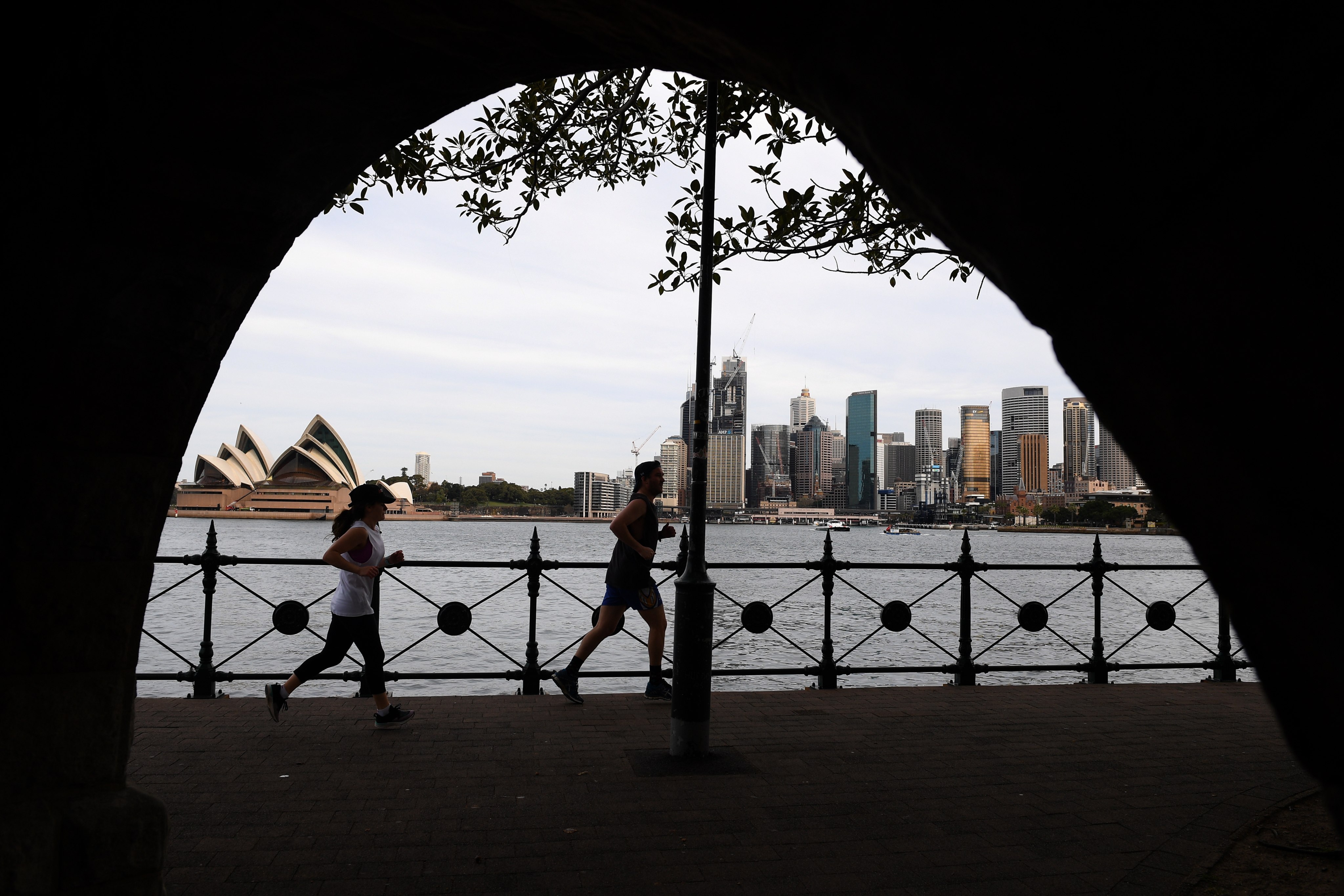 People jog in view of the skyline in Sydney, Australia on September 2, 2020. Photo: EPA-EFE