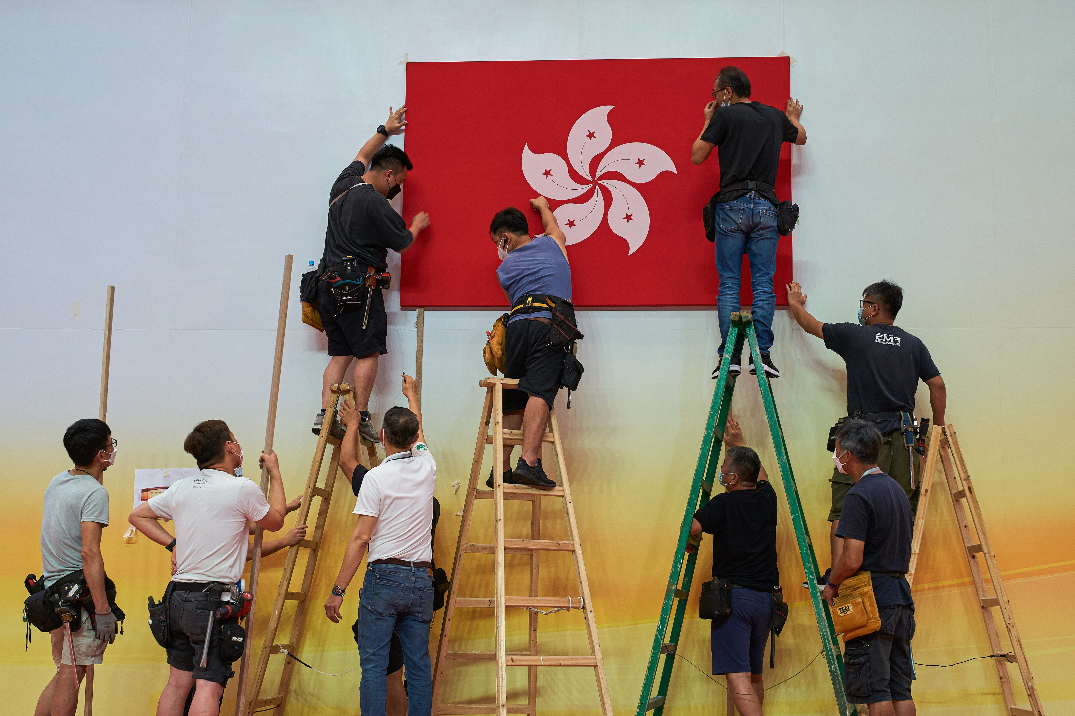 Workers mount a Hong Kong flag in Wan Chai on June 26. Photo: dpa