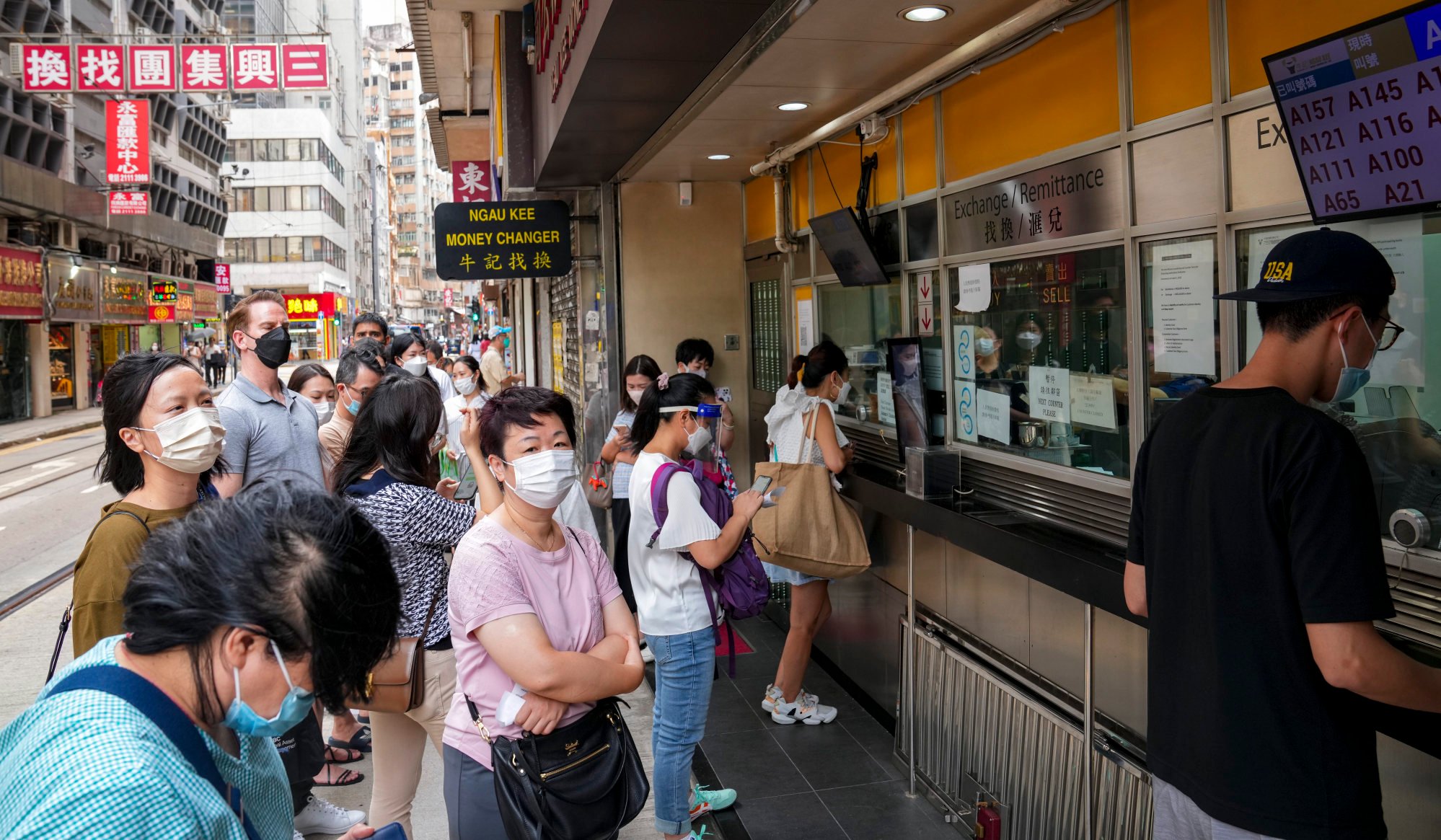 People queue up outside a currency exchange shop in Sheung Wan. Photo: Sam Tsang.