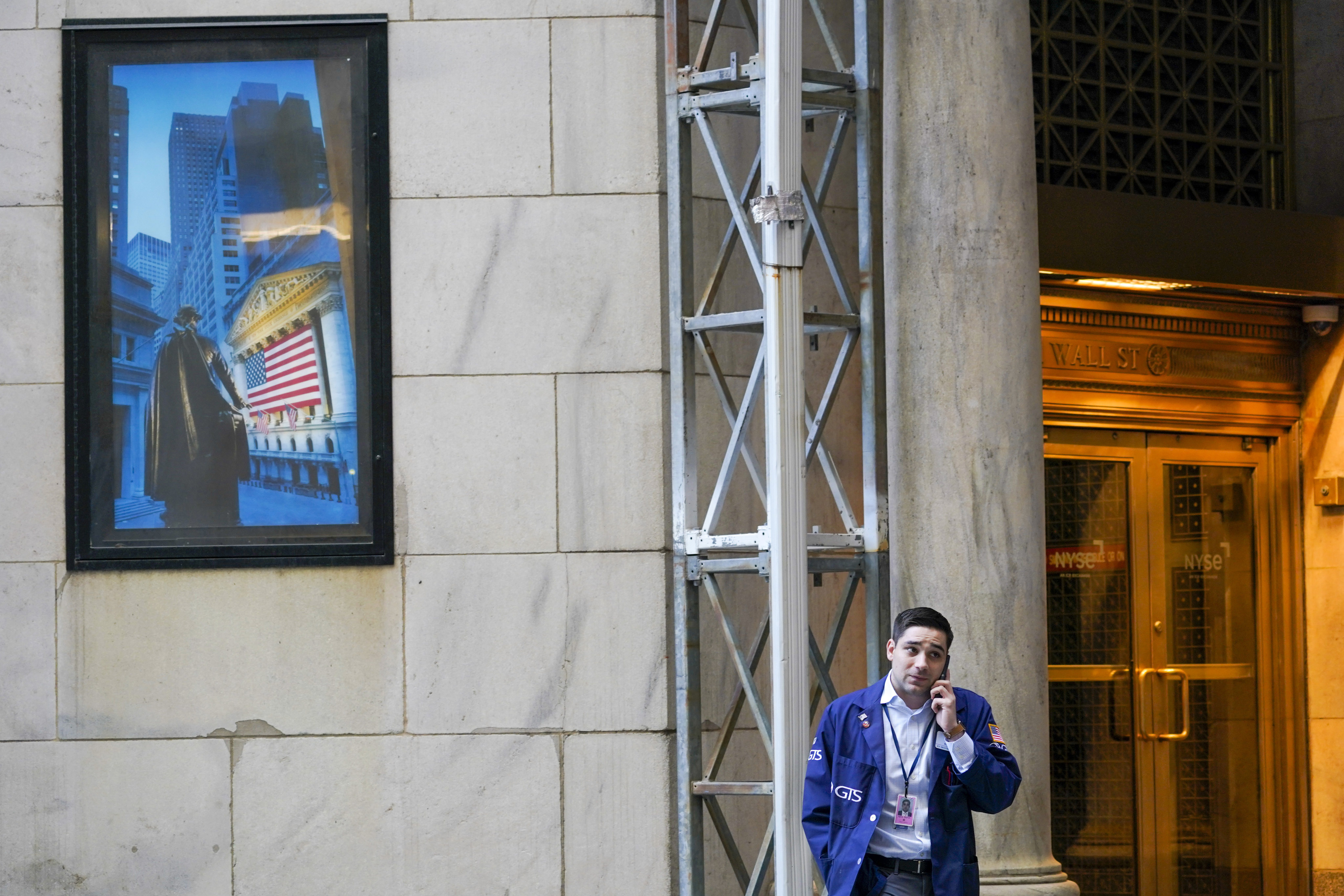 A broker talks on his phone outside the New York Stock Exchange building. Photo: AP