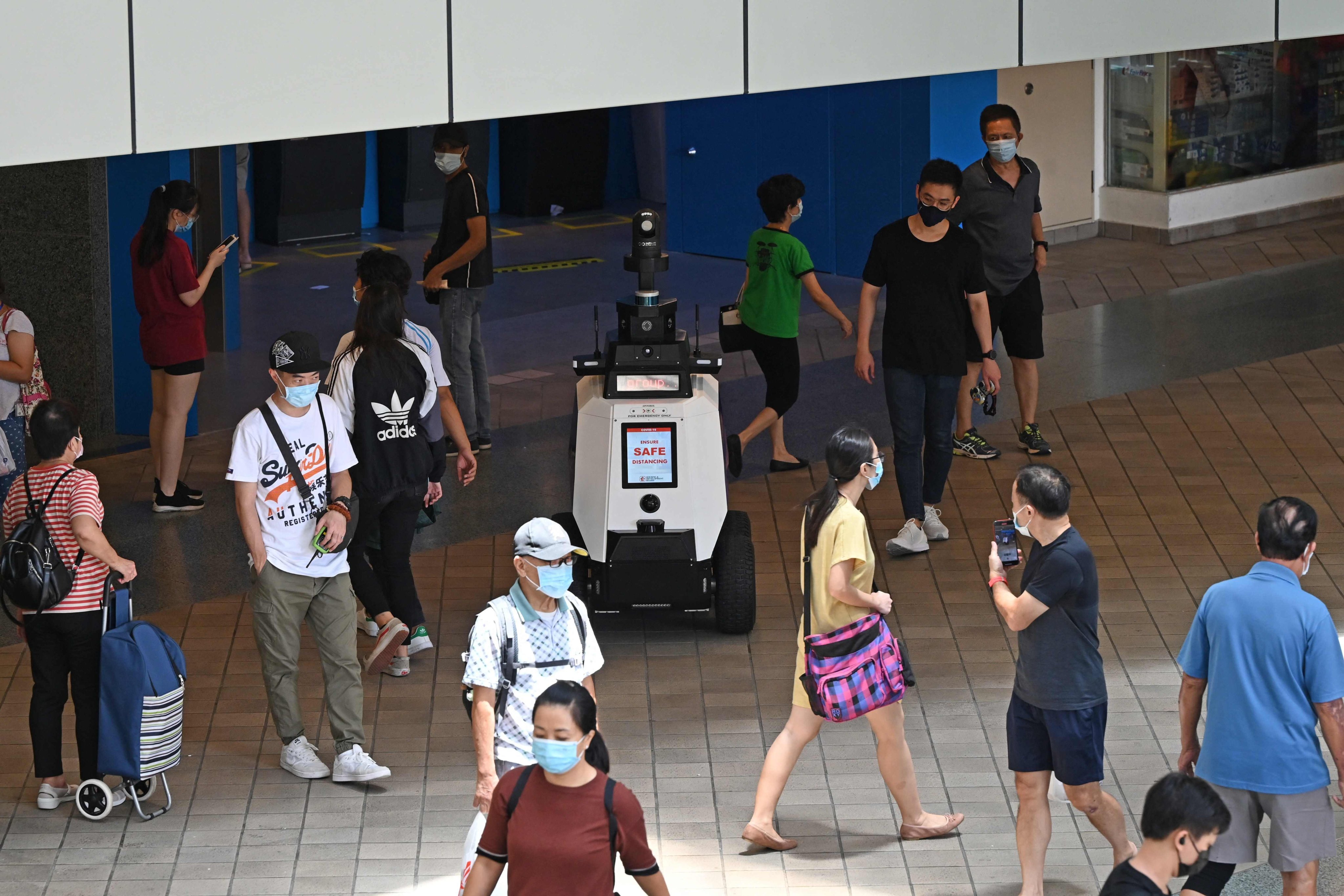 A robot patrols a residential district during a three-week trial by the Home Team Science and Technology Agency in Singapore on September 6, 2021, reminding people about proper social distancing behaviour such as not gathering in groups of more than five. Singapore sets hard targets for public officers to adopt artificial intelligence. Photo: AFP