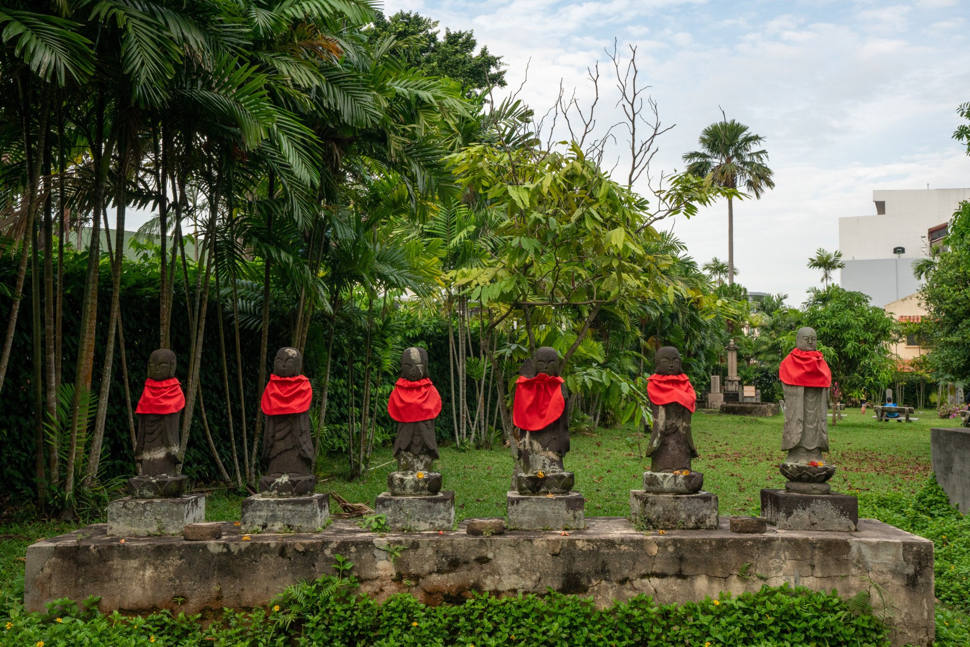Red bibs cover representations of Jizo at the Japanese Cemetery Park. Photo: Shutterstock