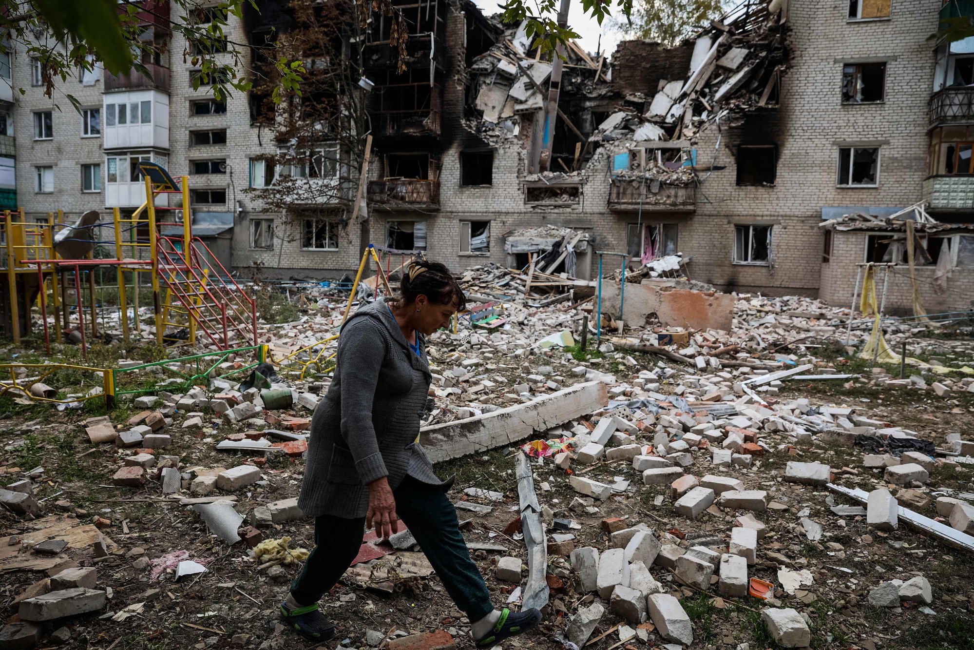 A pedestrian walks in a yard of a destroyed apartment building in the town of Sviatohirsk, Donetsk region, on Friday amid the Russian invasion of Ukraine. Photo: AFP