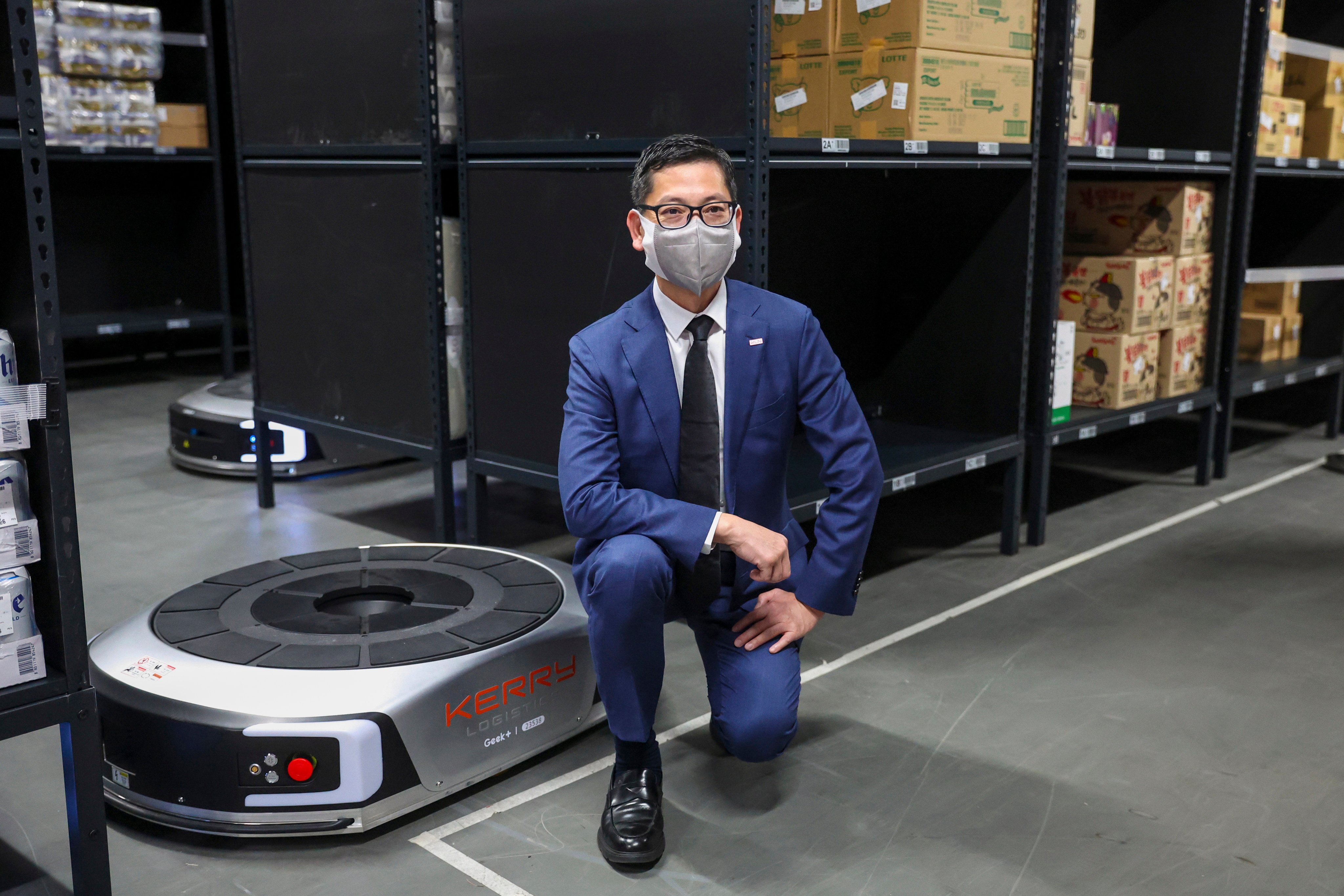 Samuel Lau, the firm’s managing director of integrated logistics in North Asia, poses with a Koolbutler robot in a Kerry Logistics warehouse in Hong Kong. Photo: Edmond So