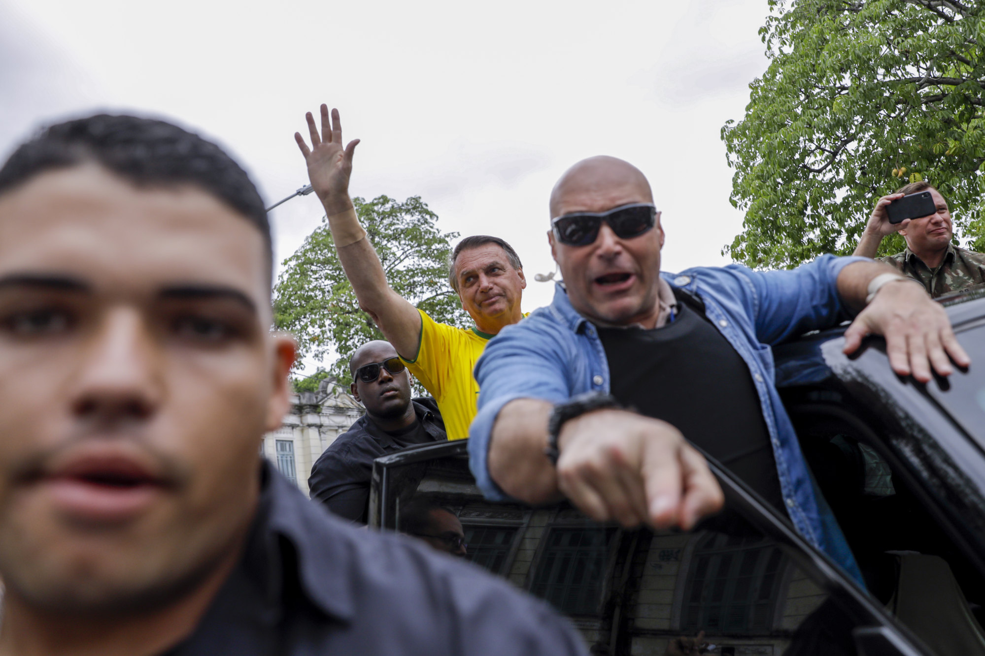 Brazil’s President Jair Bolsonaro, who is running for another term, waves as he drives away from a polling station. Photo: AP