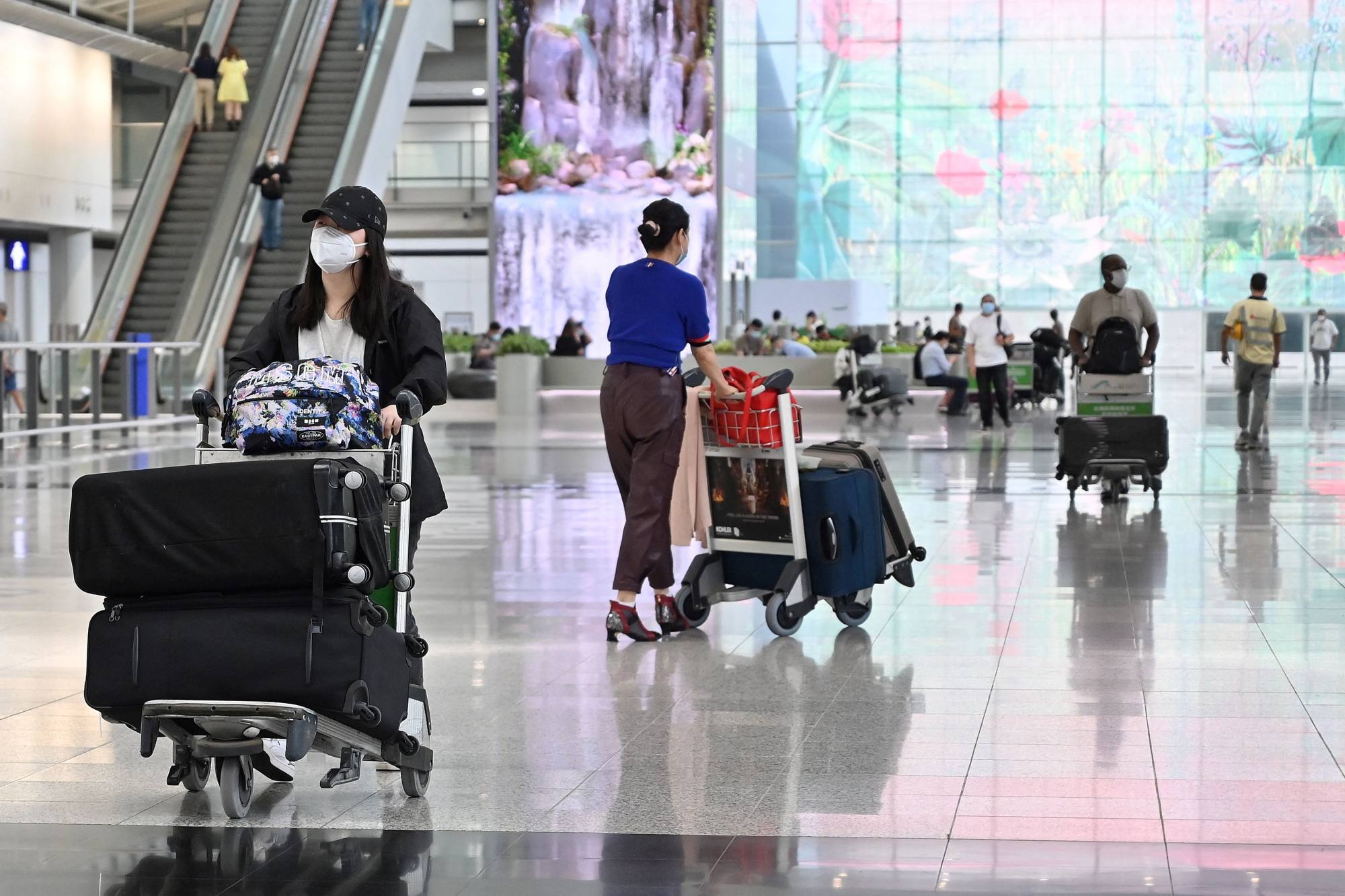 Travellers arrive at Hong Kong’s international airport after the compulsory quarantine is lifted. Photo: AFP