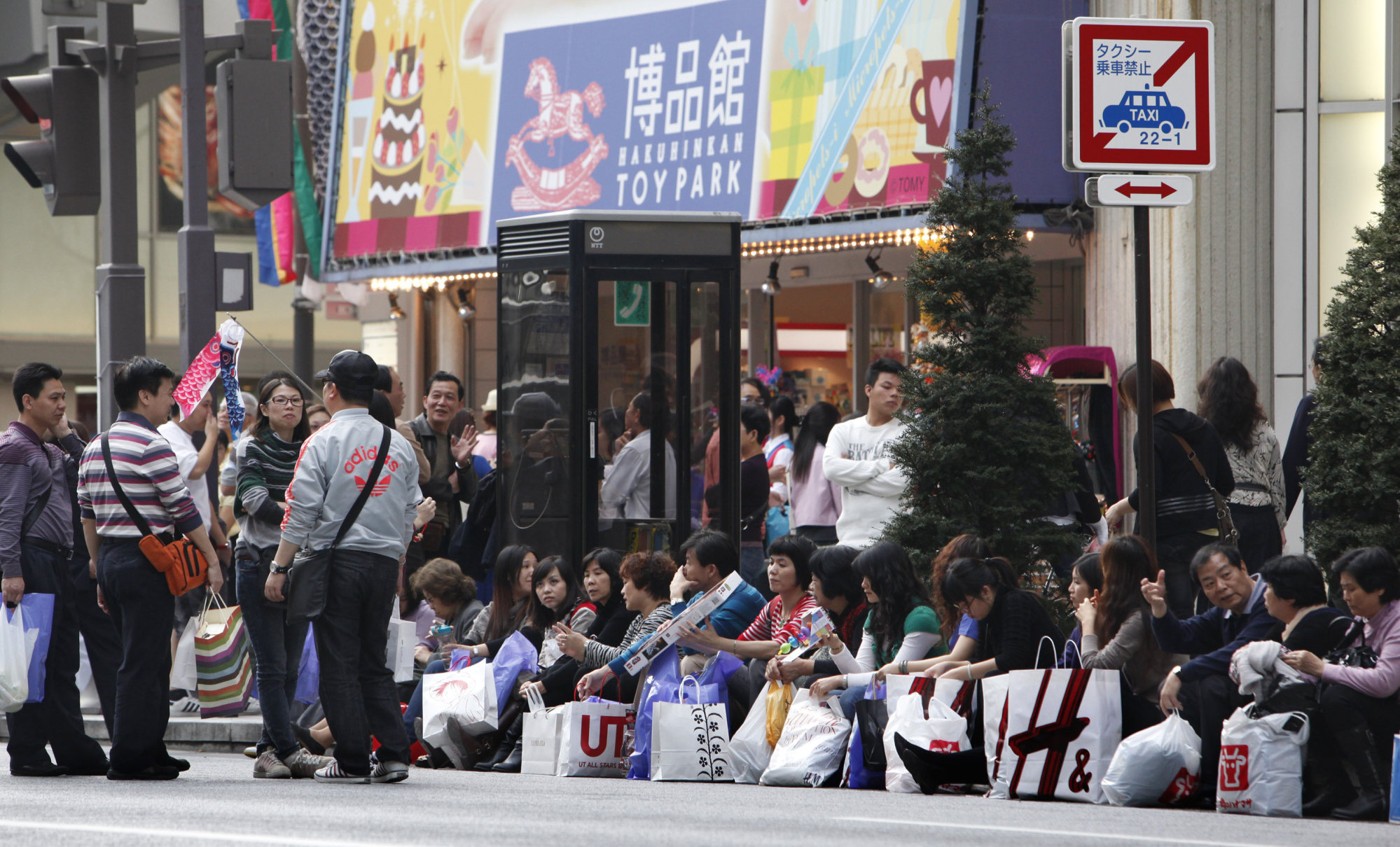 Chinese tourists take a break after shopping in Tokyo’s posh Ginza district on April 11, 2010. China’s continued strict Covid-19 restrictions are unlikely to boost visitor arrivals in Japan any time soon. Photo: AP