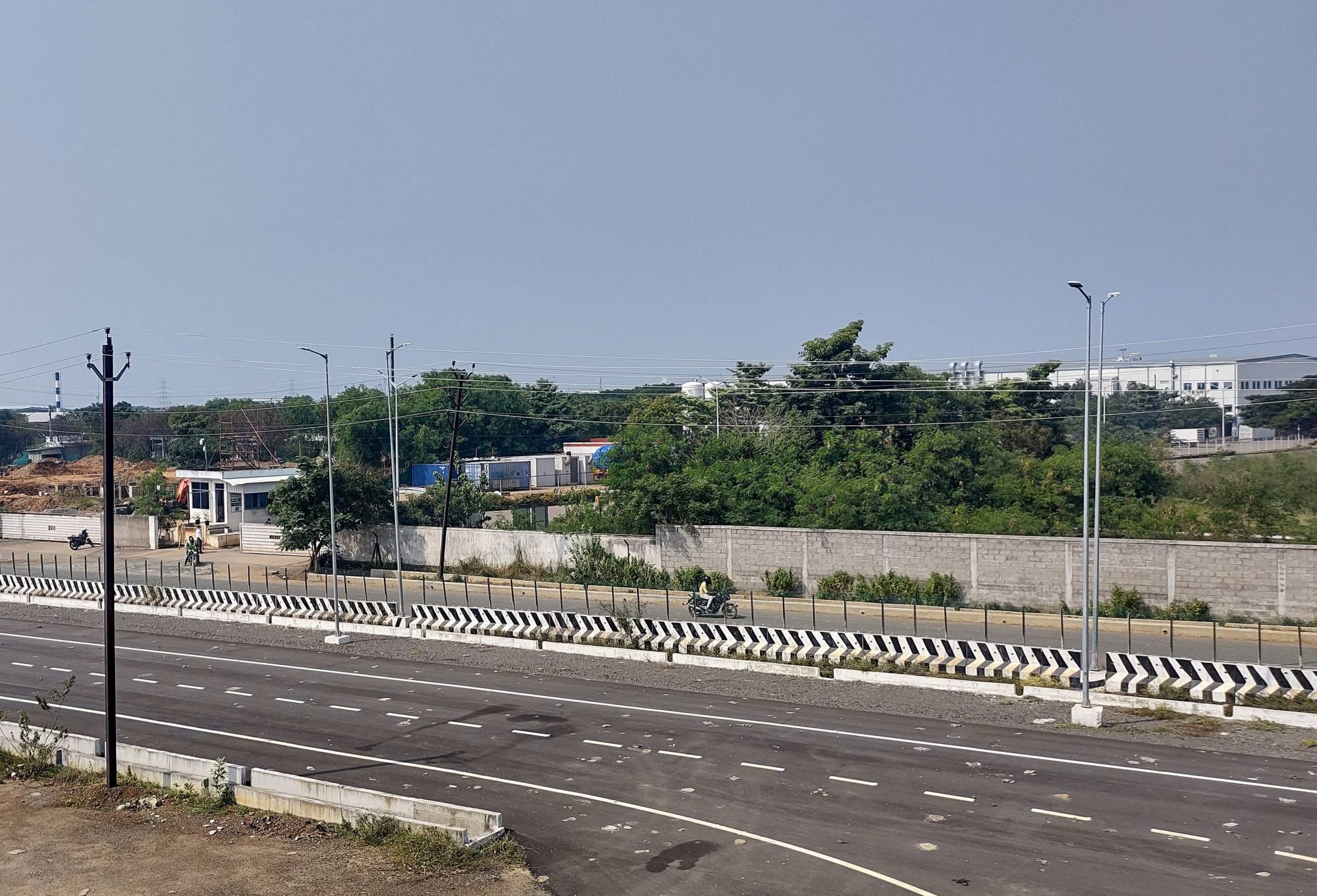 Men ride their motorbikes past a closed Foxconn plant near Chennai, India, on December 21, 2021. Photo: Reuters