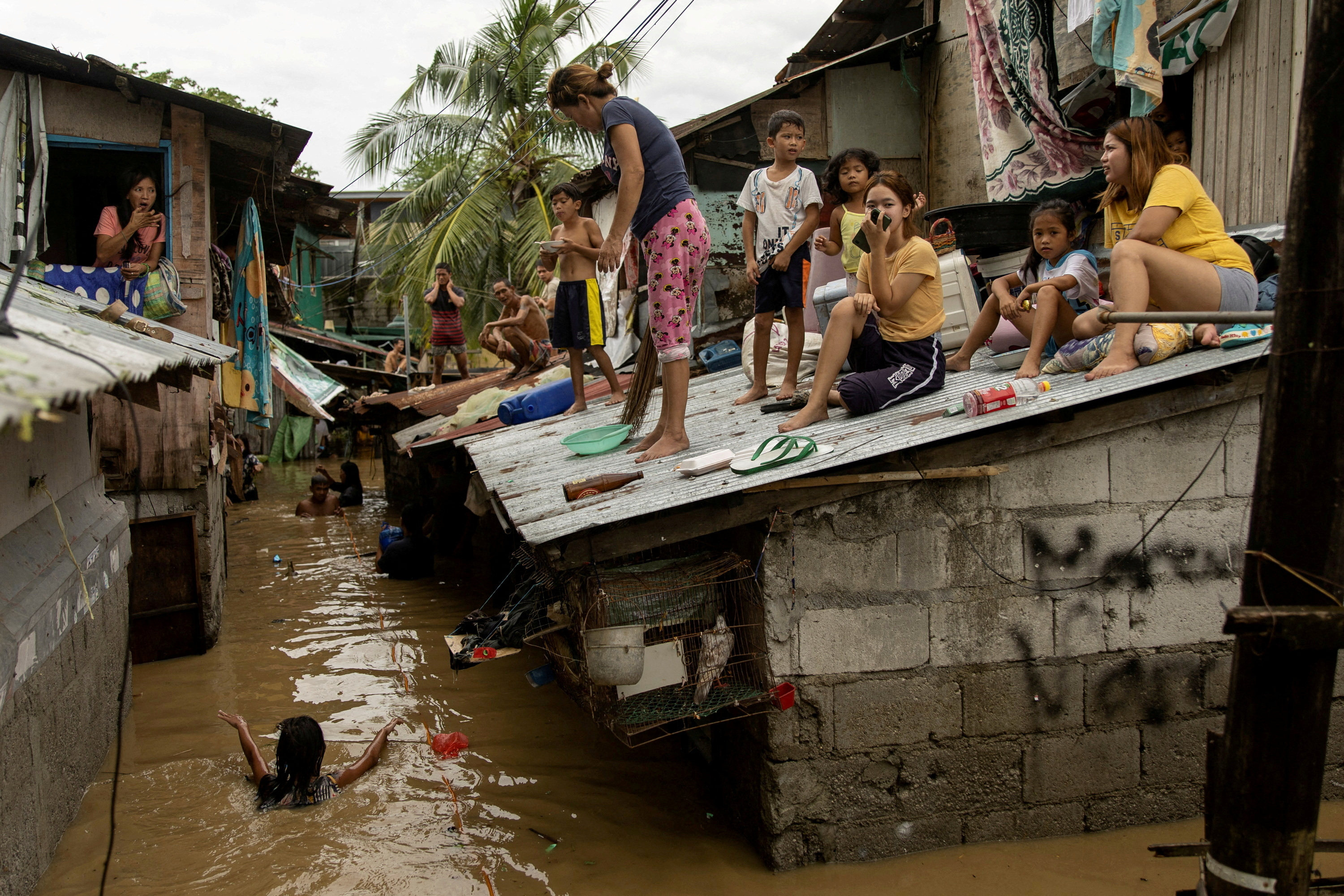 Residents wait on the roof for flooding to subside after Super Typhoon Noru in San Miguel, Bulacan province, Philippines, on September 26. Photo: Reuters