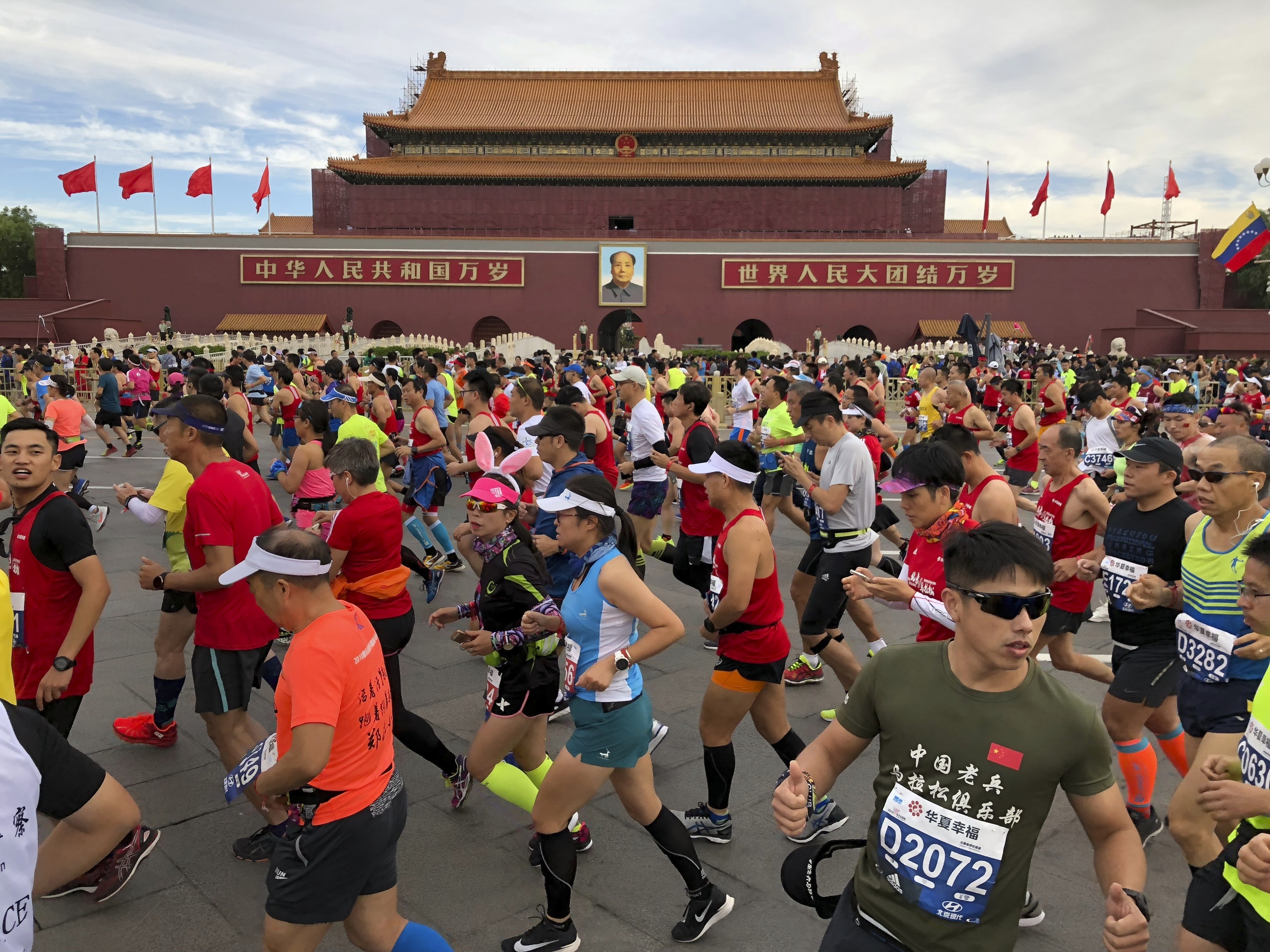 Runners pass near the large portrait of Chinese leader Mao Zedong on Tiananmen Gate near Tiananmen Square at the start of the Beijing Marathon on September 16, 2018. Photo: AP
