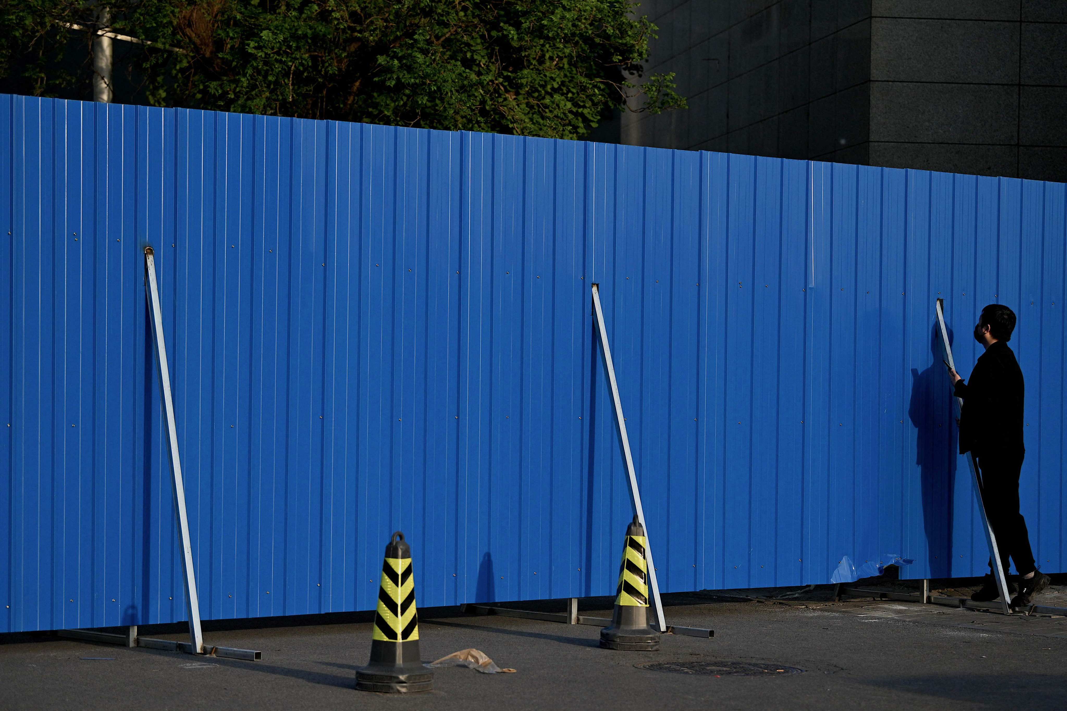 A man talks to a resident confined in a fenced residential area under lockdown due to Covid-19 restrictions in Beijing, on May 17. Photo: AFP
