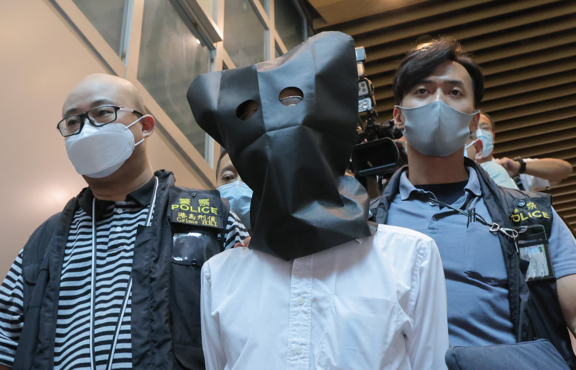 Police officers escort a suspect from the clinic of Dr Wong Ping-leung in Hing Wah Plaza last month. Photo: SCMP