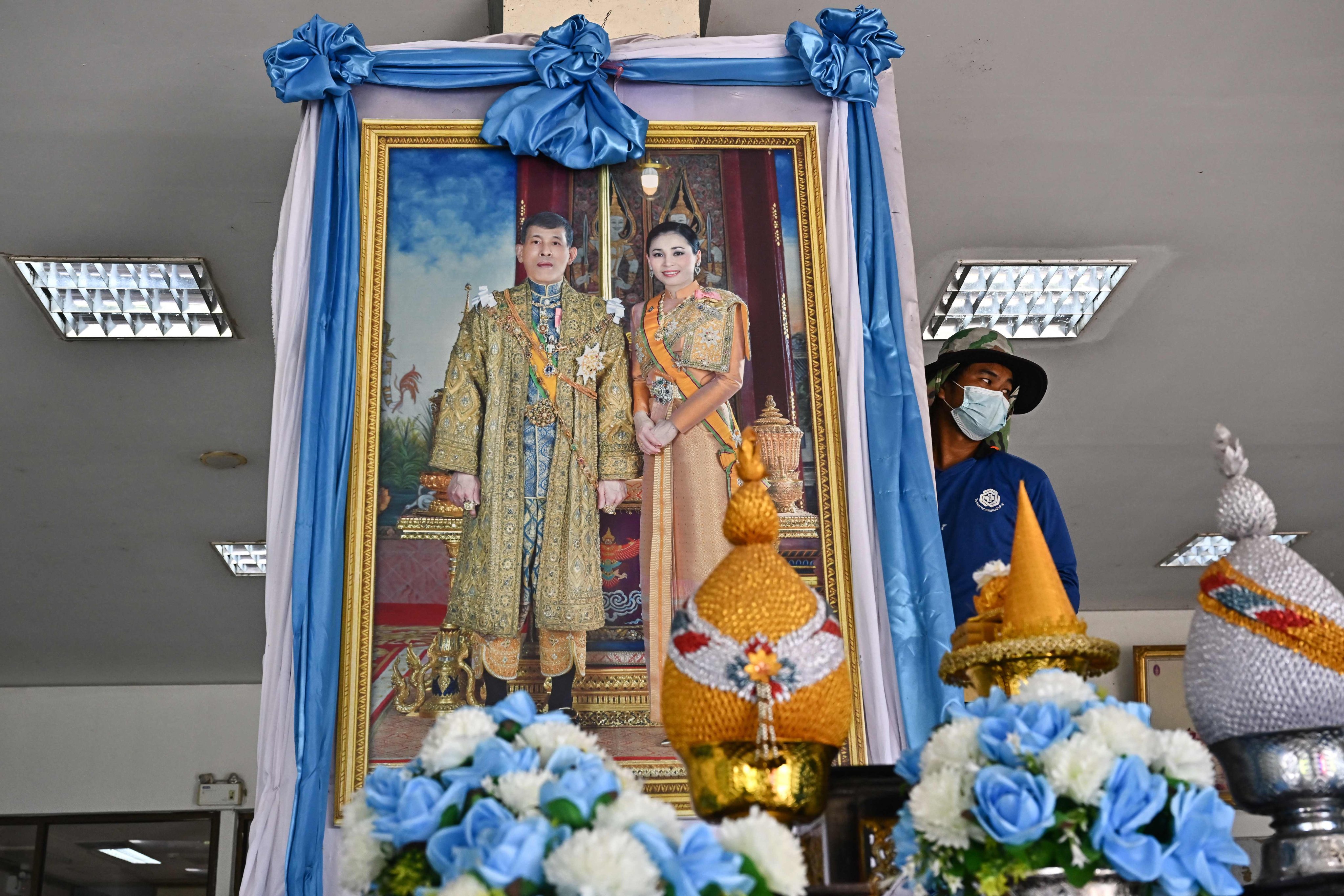 A worker sets up a portrait of Thailand’s King Maha Vajiralongkorn and Queen Suthida ahead of their visit to the hospital where injured survivors were taken after a mass shooting at a nursery. Photo: AFP
