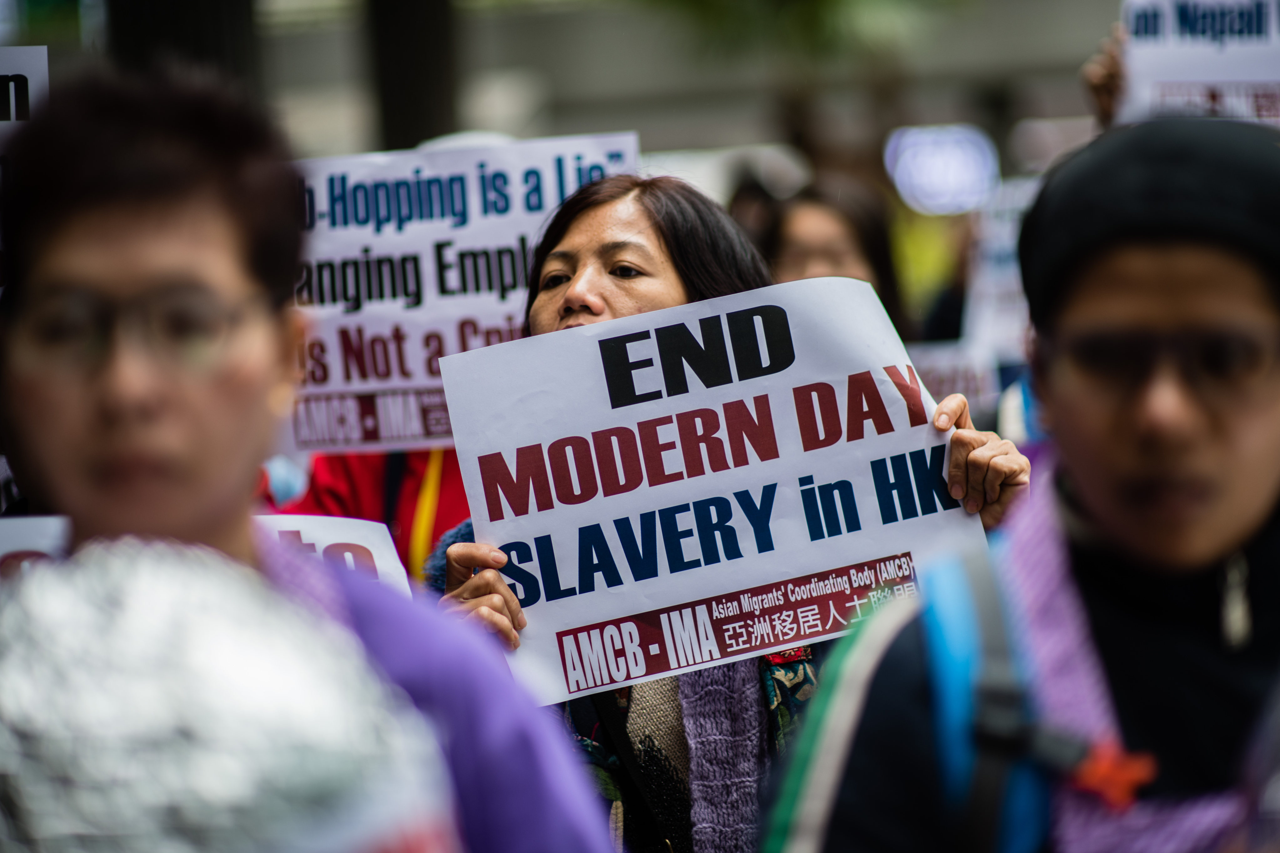 An activist from the Asian Migrants Coordinating Body holds a placard during a protest urging the Immigration Department to review its accommodation and visa polices for foreign domestic helpers in Hong Kong in 2018. Photo: AFP 