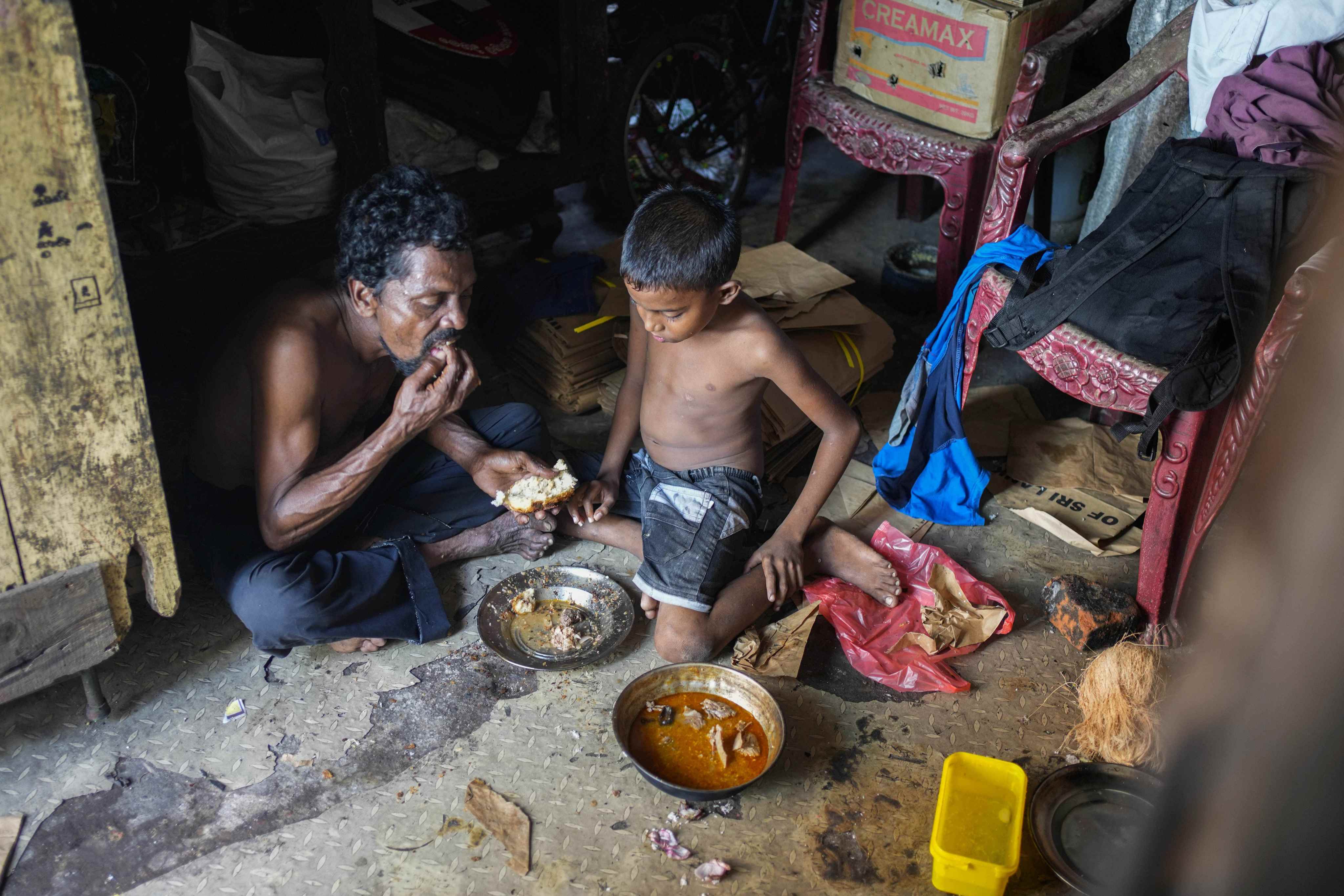A father and son share a meal at their shanty home in Colombo, Sri Lanka, on October 5. The country is currently facing its worst economic crisis in decades. Photo: AP