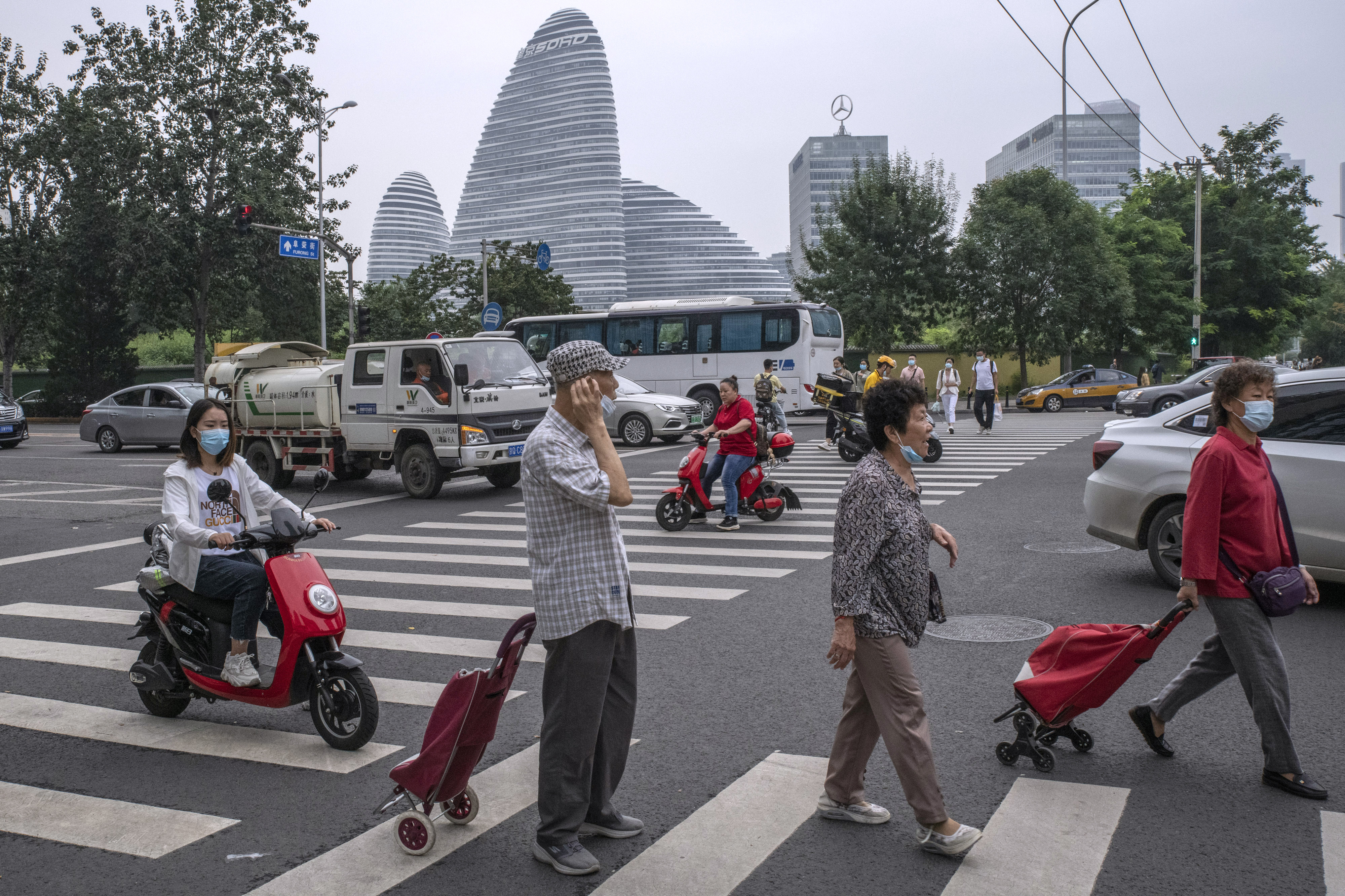 Pedestrians cross a road in Beijing on September 14, 2021. Most of China’s tax revenues come from value-added taxes, consumption (luxury) taxes and social security contributions, which are regressive. Photo: Bloomberg