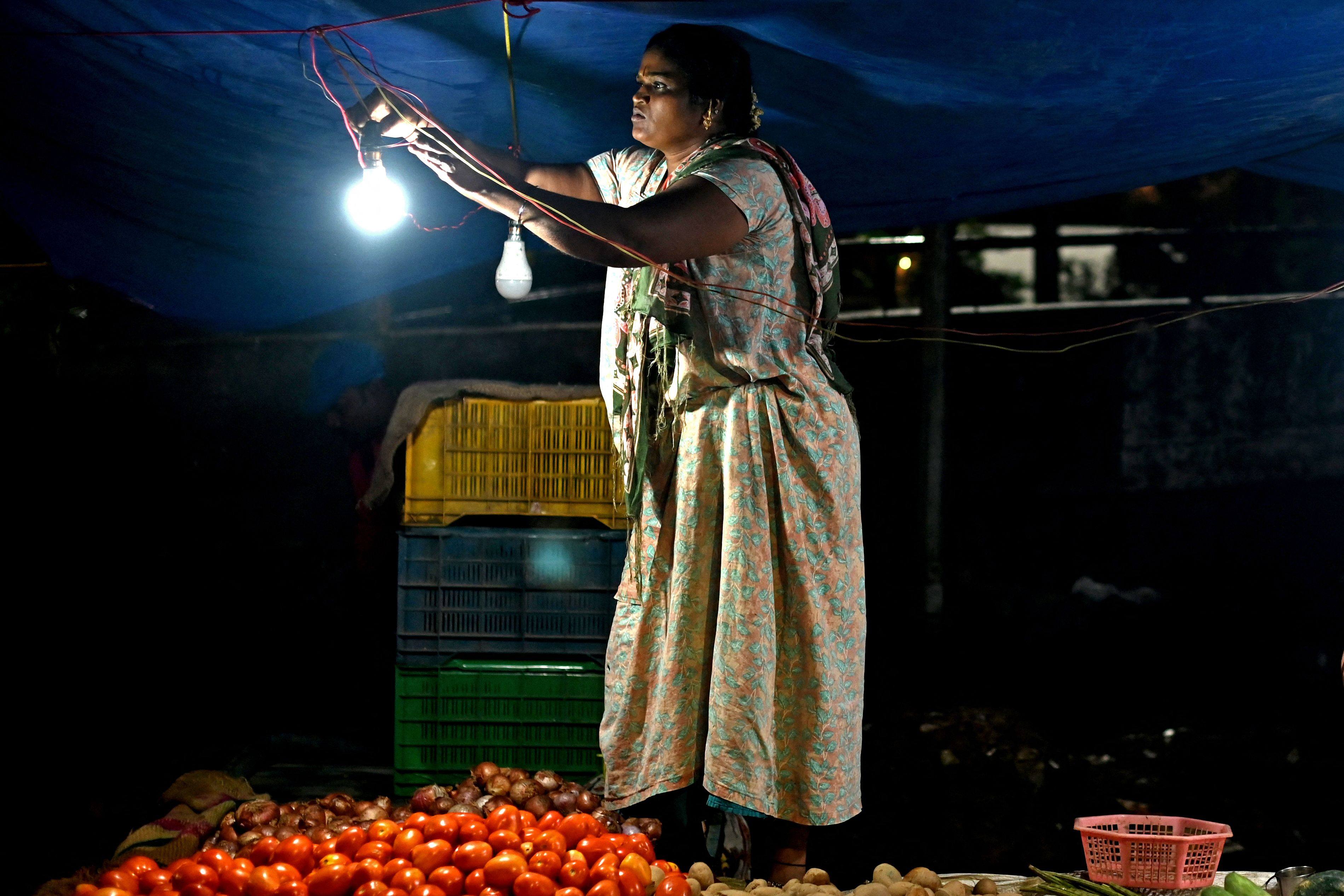 A vendor fixes a light bulb at a vegetable market in New Delhi. India’s economy is forecast to grow by a brisk 6.8 per cent this year. Photo: AFP