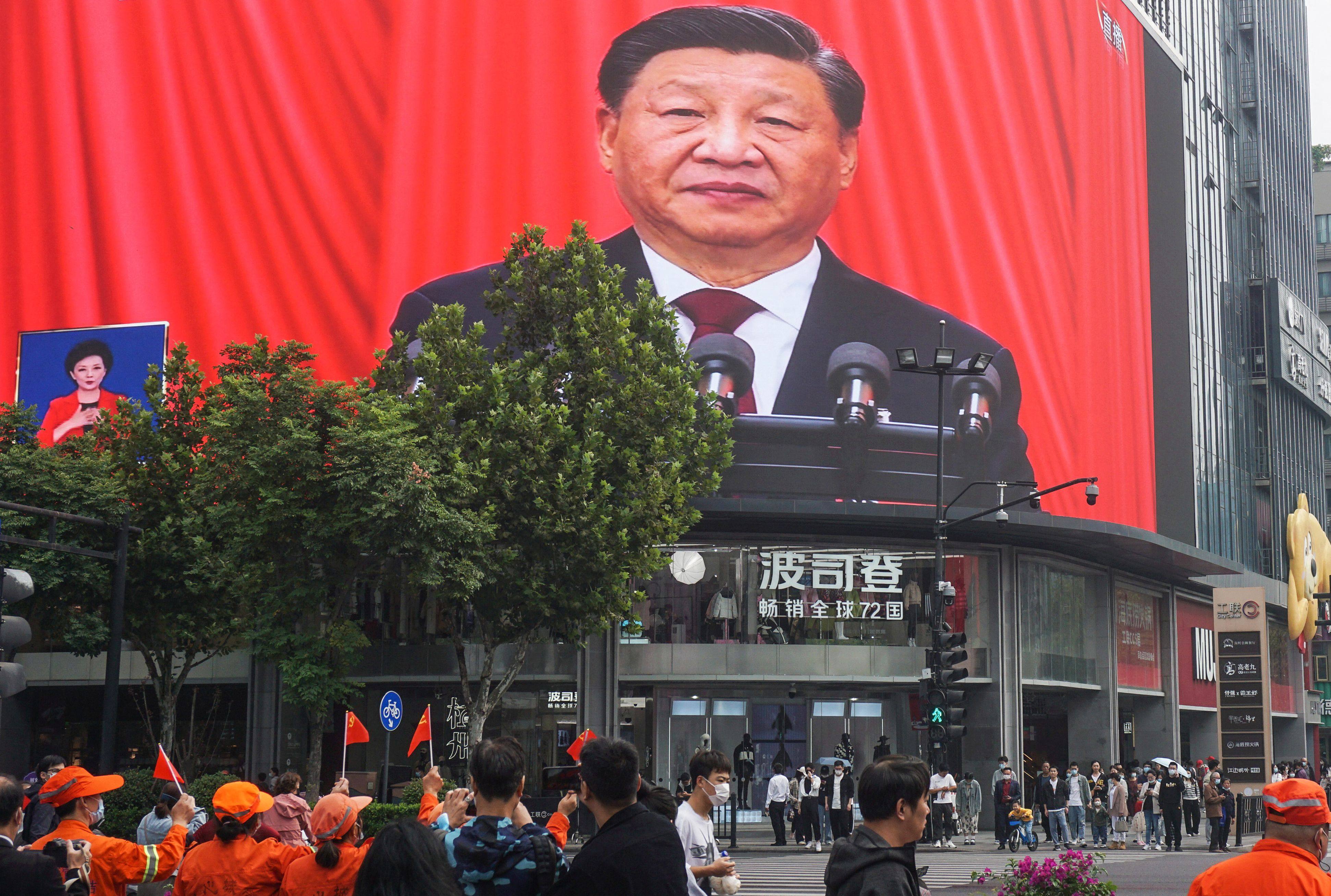 People in Hangzhou watch an outdoor screen showing President Xi Jinping addressing the Communist Party congress on Sunday. Photo: AFP