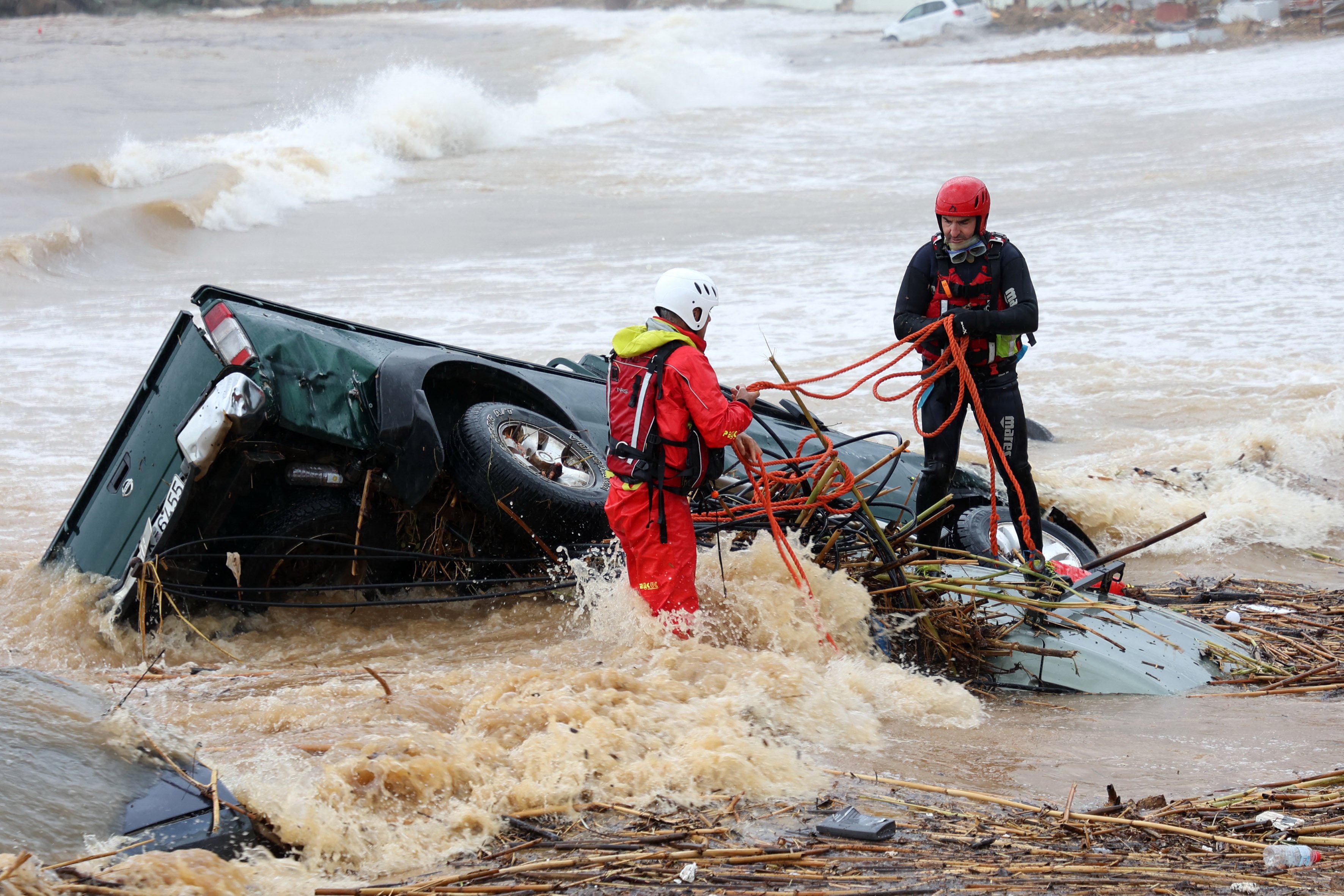 Rescuers try to retrieve a vehicle pushed by flood waters into the sea along the beach of the resort of Agia Pelagia, on the Greek island of Crete following flash floods on Saturday. Photo: AFP