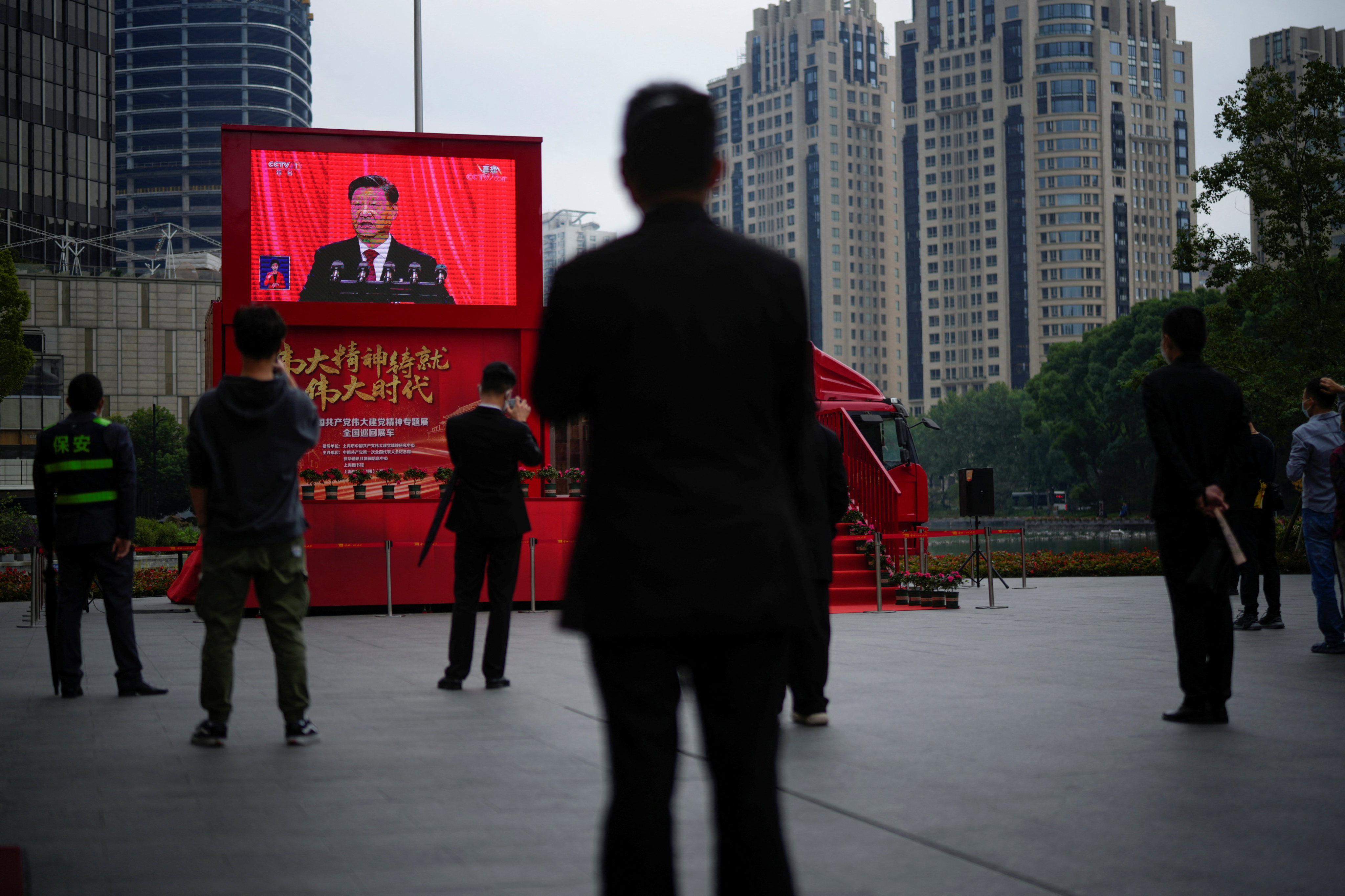 In Shanghai, people watch a screen showing the live broadcast of Chinese President Xi Jinping attending the opening ceremony of the Communist Party congress on Sunday. Photo: Reuters