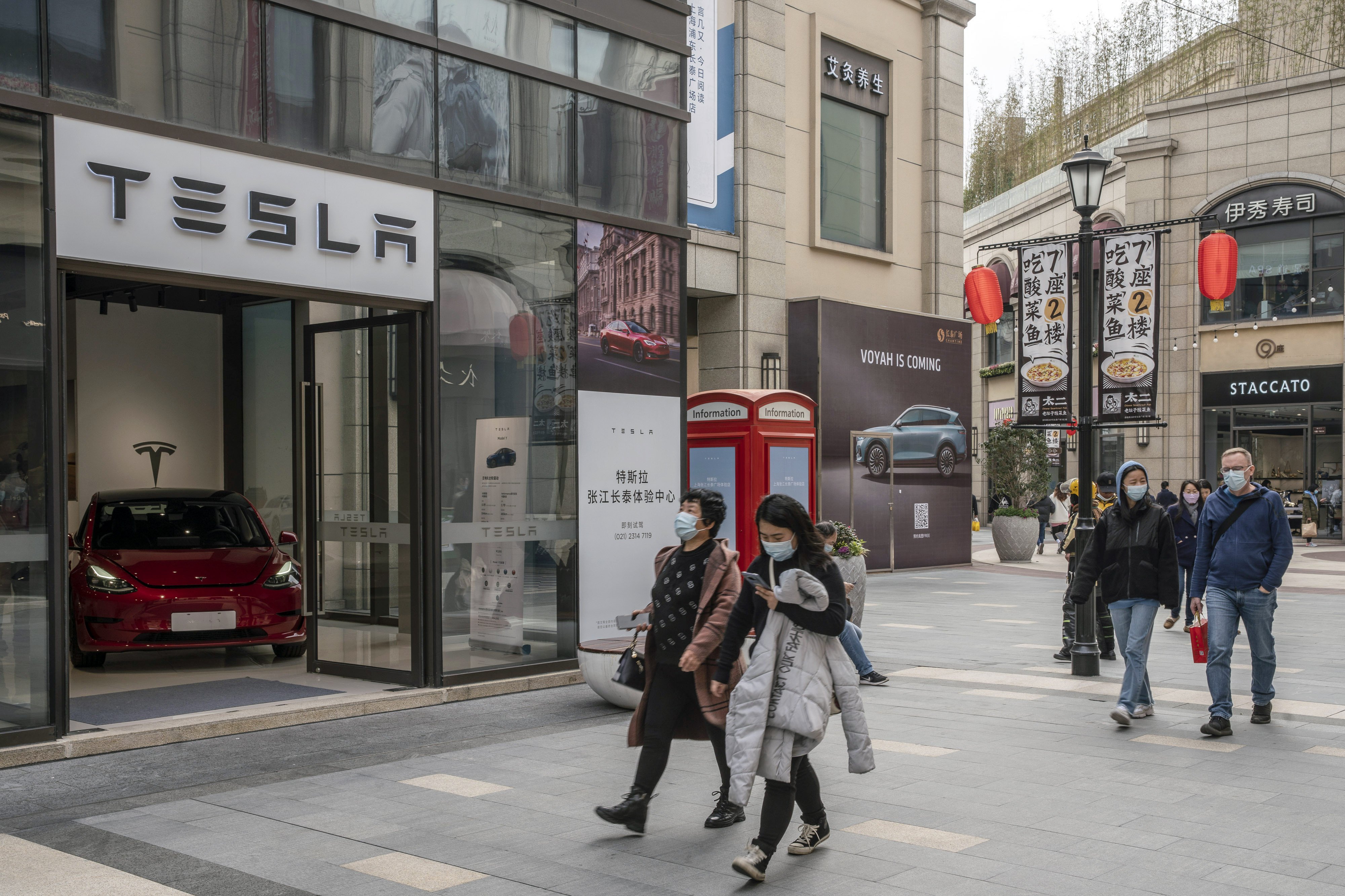 Shoppers walk past a Tesla showroom in Shanghai on March 8, 2021. Photo: Bloomberg
