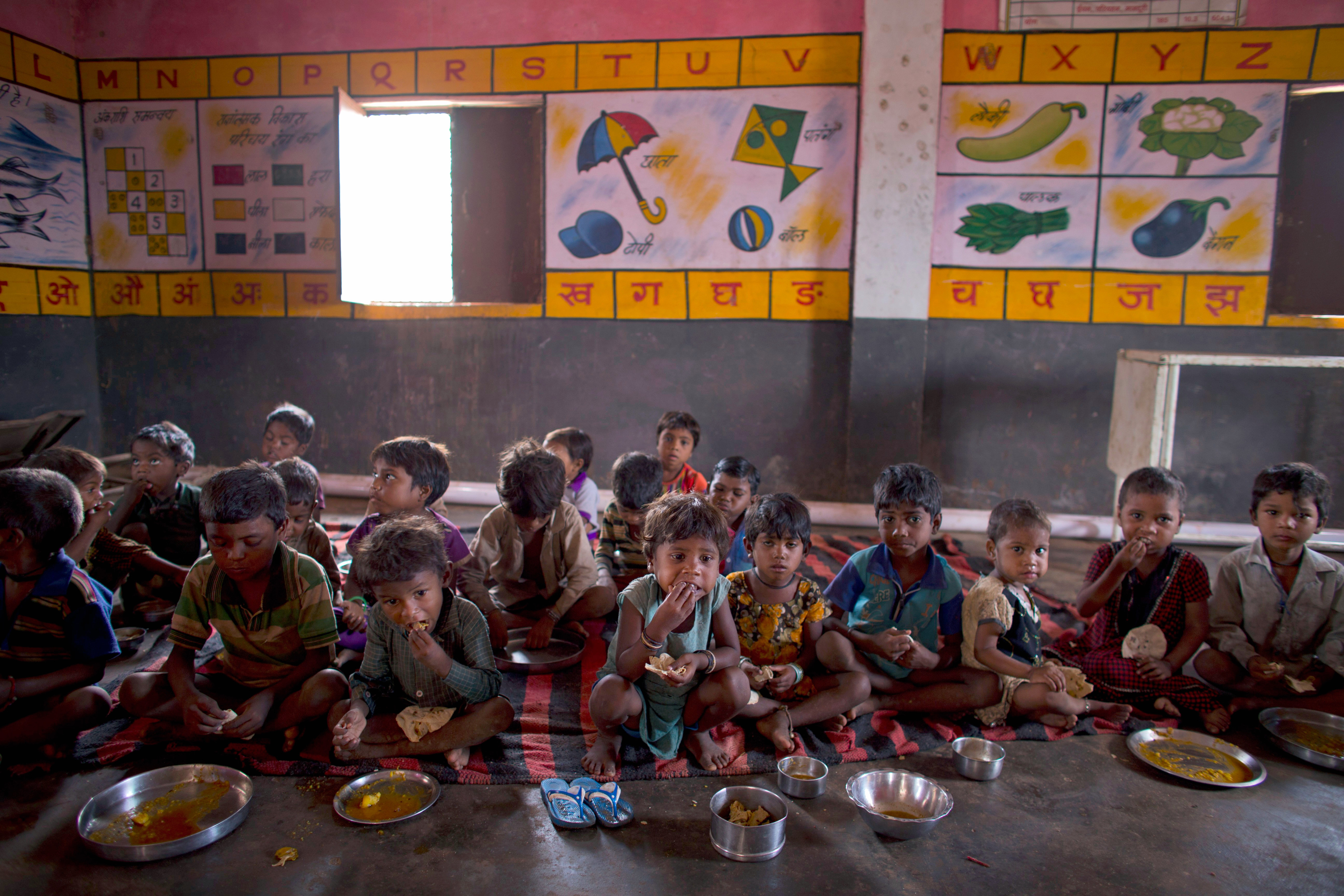 Children have a meal of two flatbreads and a scoop of boiled potato curry at a government-run programme in Madhya Pradesh state, India. Photo: AP