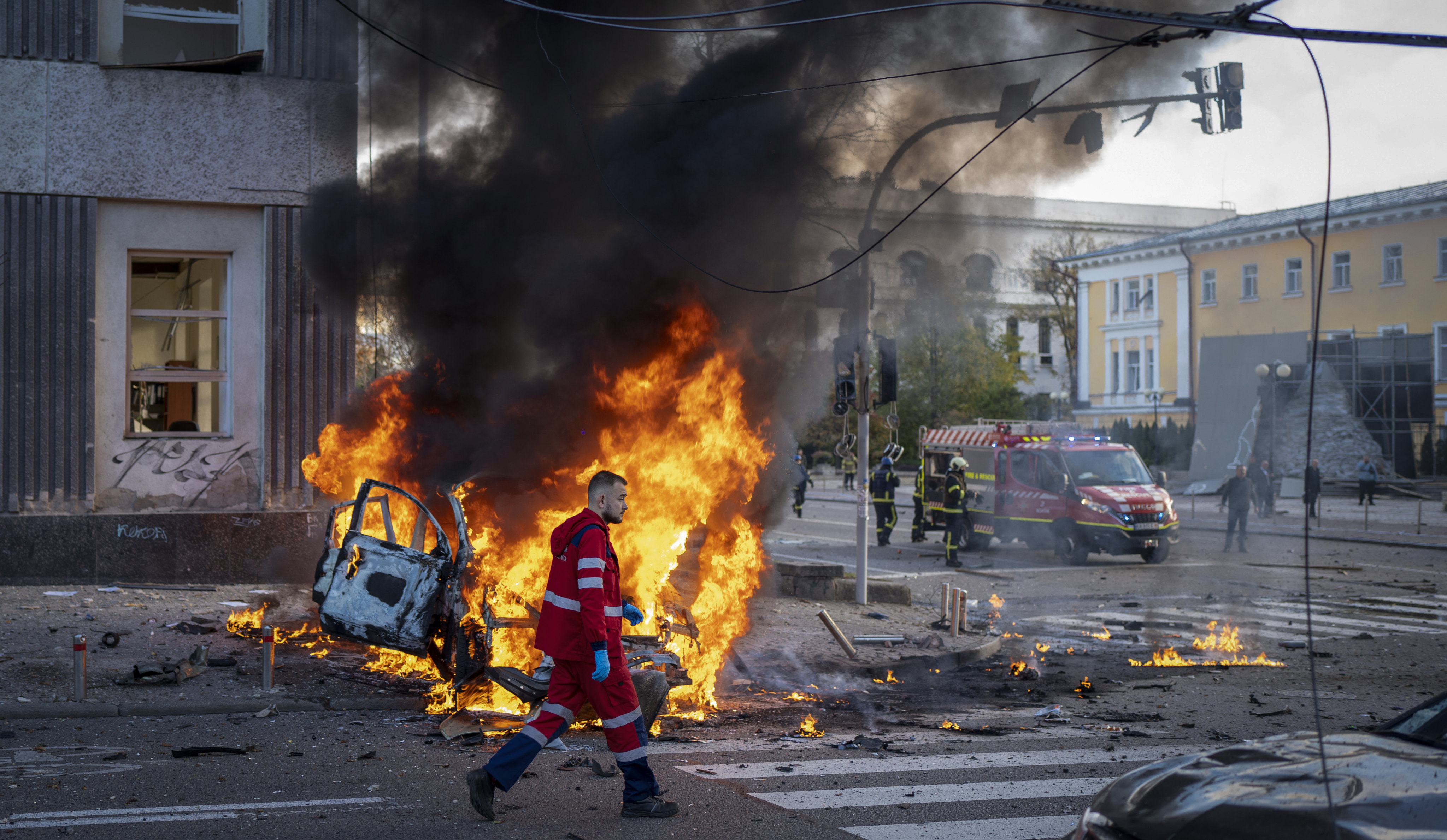 A medical worker walks past a burning car after a Russian attack on Kyiv, Ukraine, on October 10. Photo: AP 