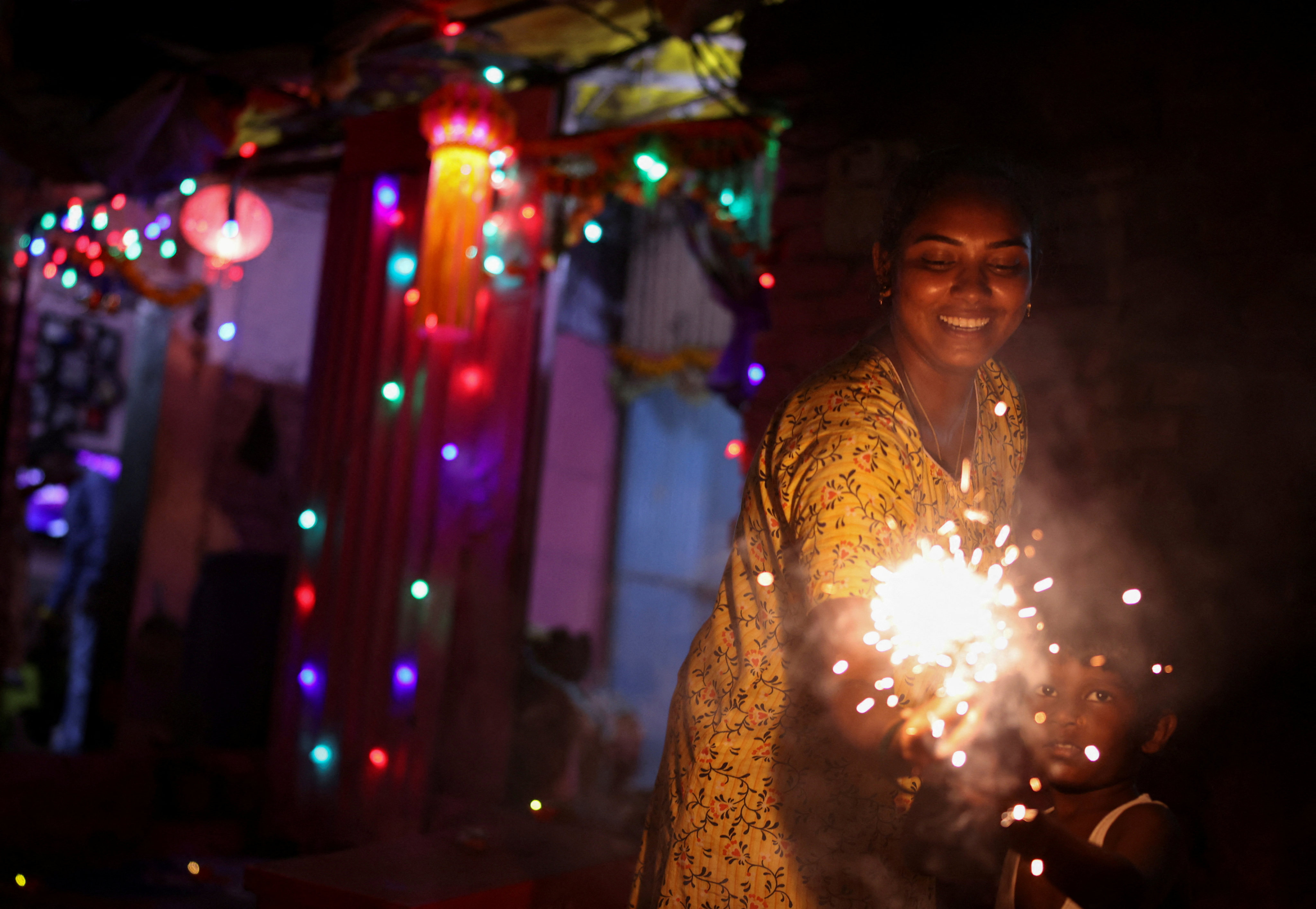 A woman and her son hold firecrackers during the 2021 Diwali festival in Mumbai. Photo: Reuters