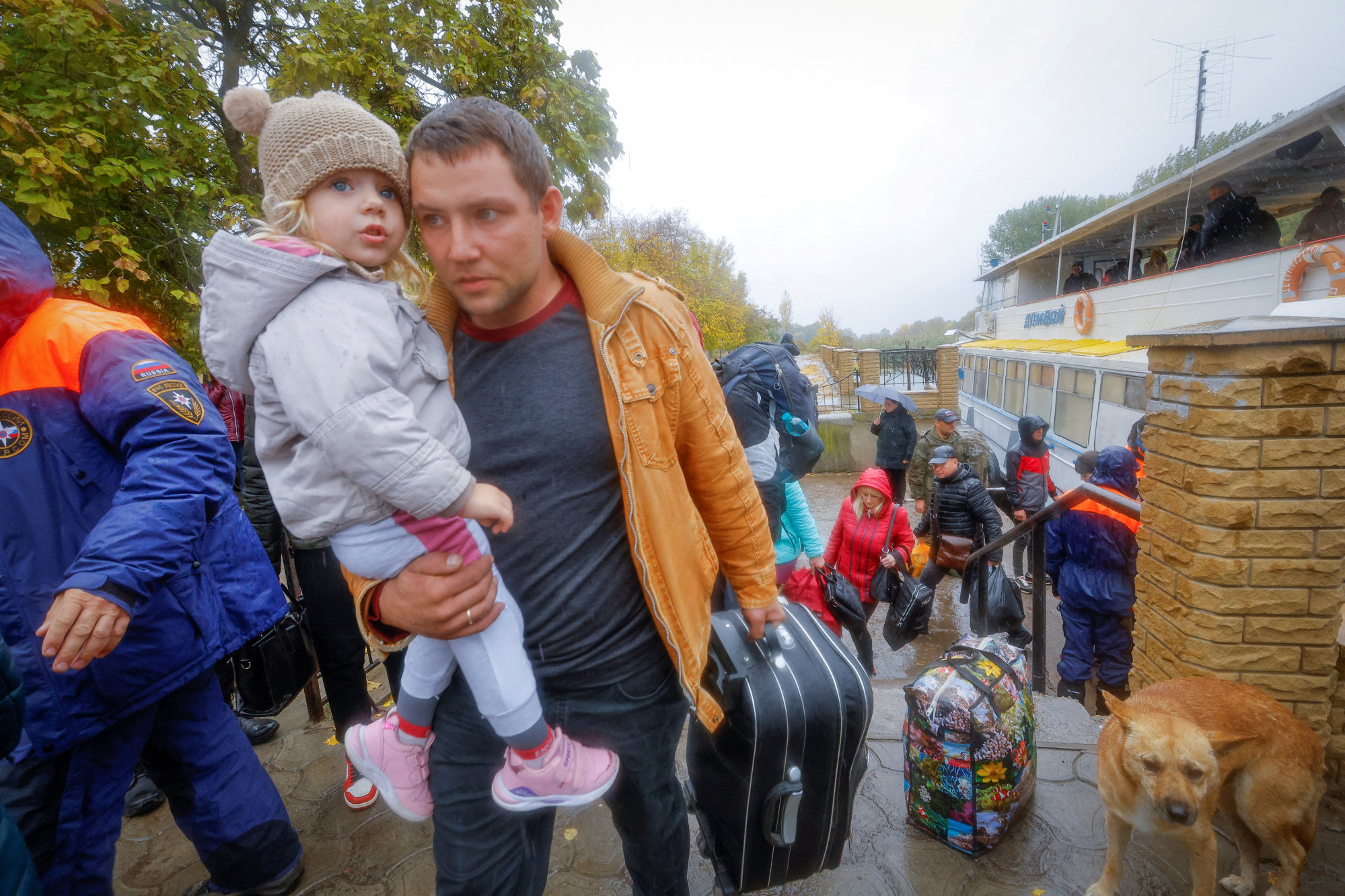 Civilians evacuated from the Russian-controlled city of Kherson walk from a ferry to board a bus heading to Crimea. Photo: Reuters