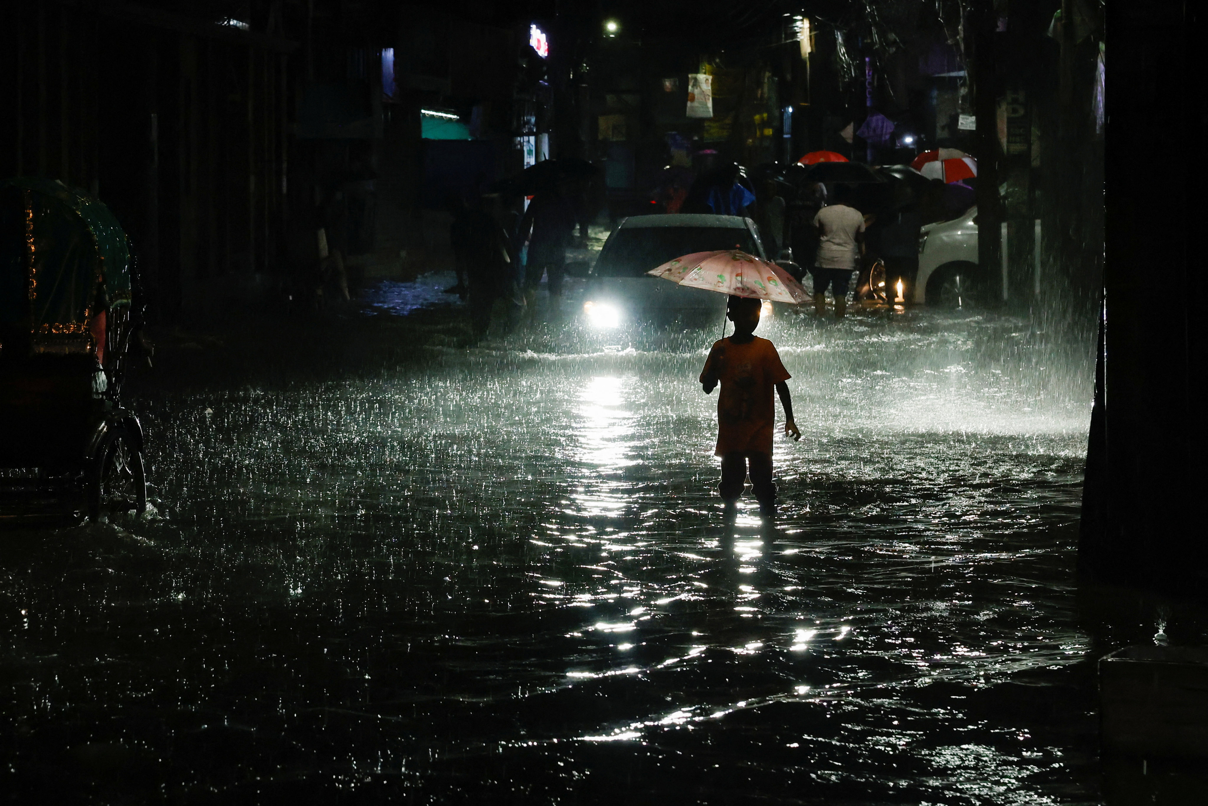 A boy in Dhaka wades through a street flooded by continuous rain before Cyclone Sitrang made landfall on Monday. Photo: Reuters