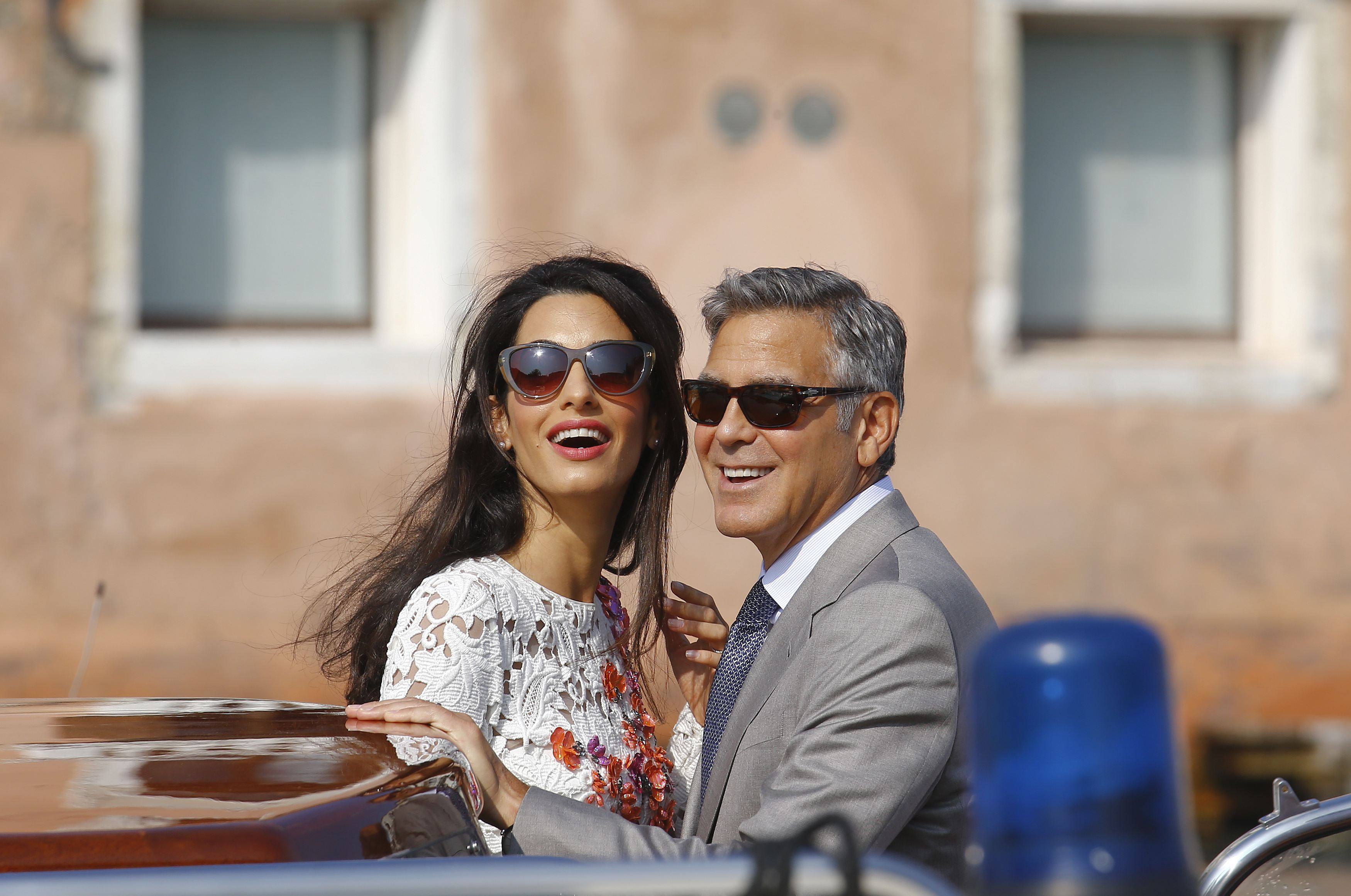 U.S. actor George Clooney and his wife Amal Alamuddin stand in a water taxi on the Grand Canal in Venice in this September 28, 2014 file photo. REUTERS/Stefano Rellandini/Files (ITALY - Tags: TPX IMAGES OF THE DAY ENTERTAINMENT)