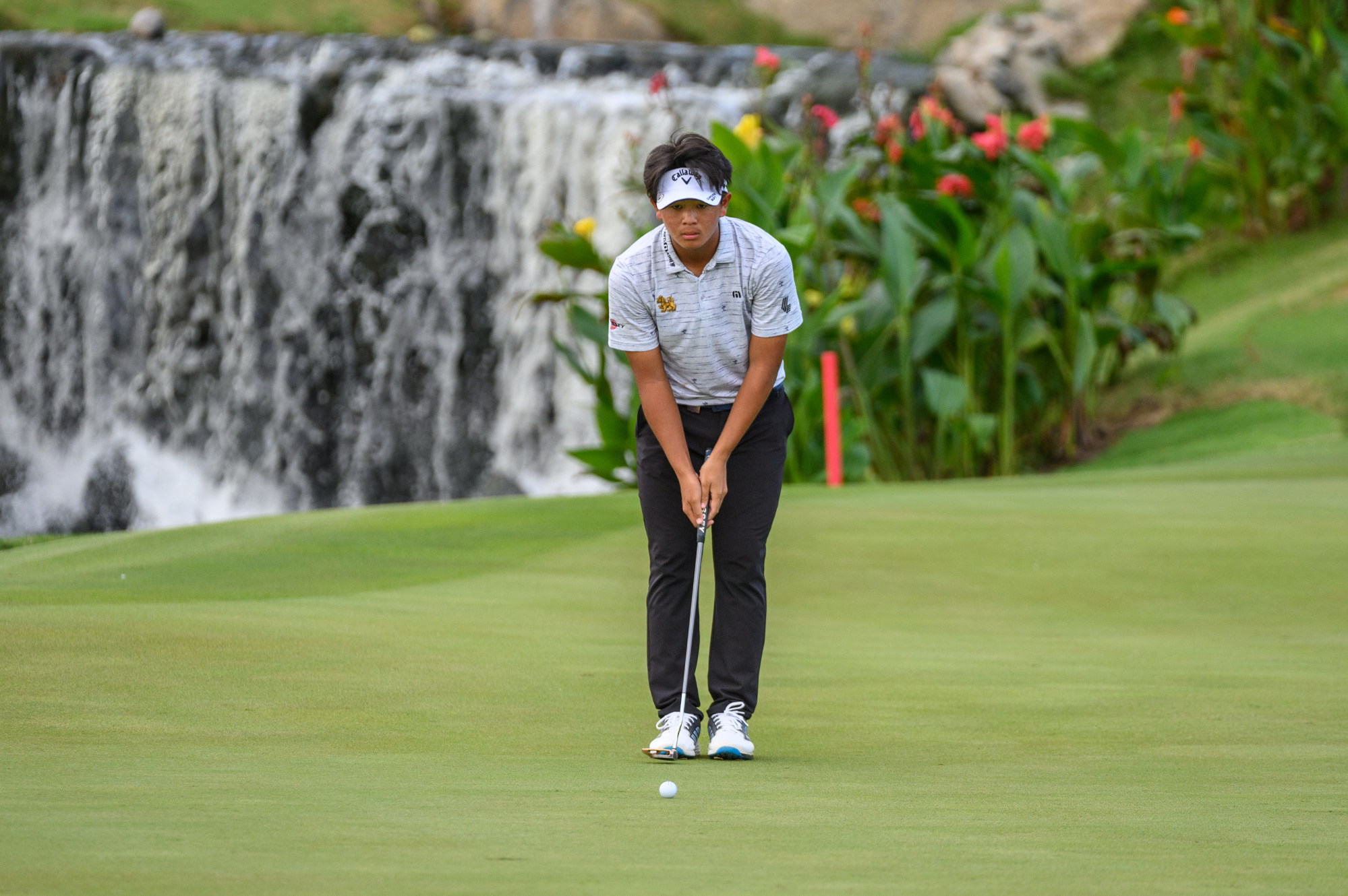 TK Chantananuwat of Thailand lines up a putt on the 18th green.