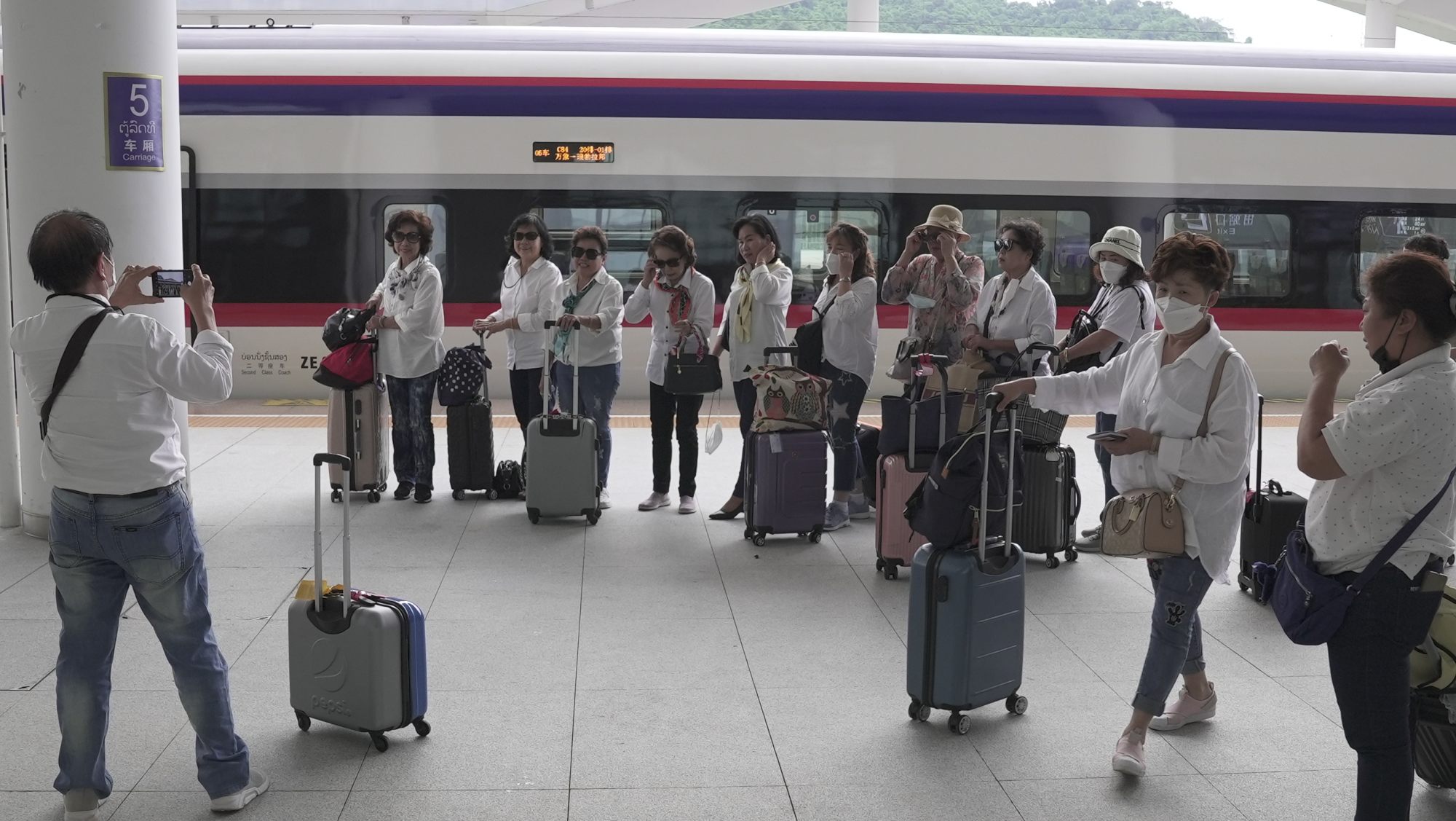 Thai tourists pose for selfies on arrival at Luang Prabang station in Laos. Photo: Aidan Jones