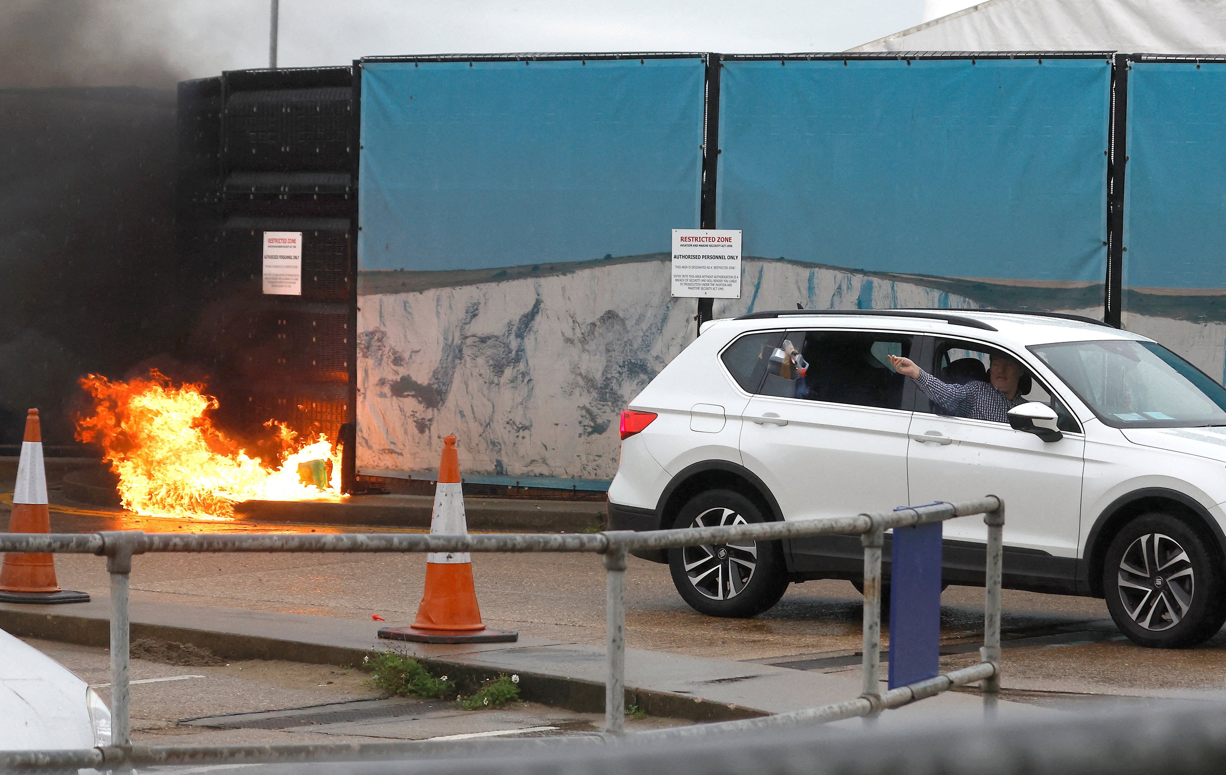 A man throws an object out of a car window next to the Border Force centre after a firebomb attack in Dover. Photo: Reuters