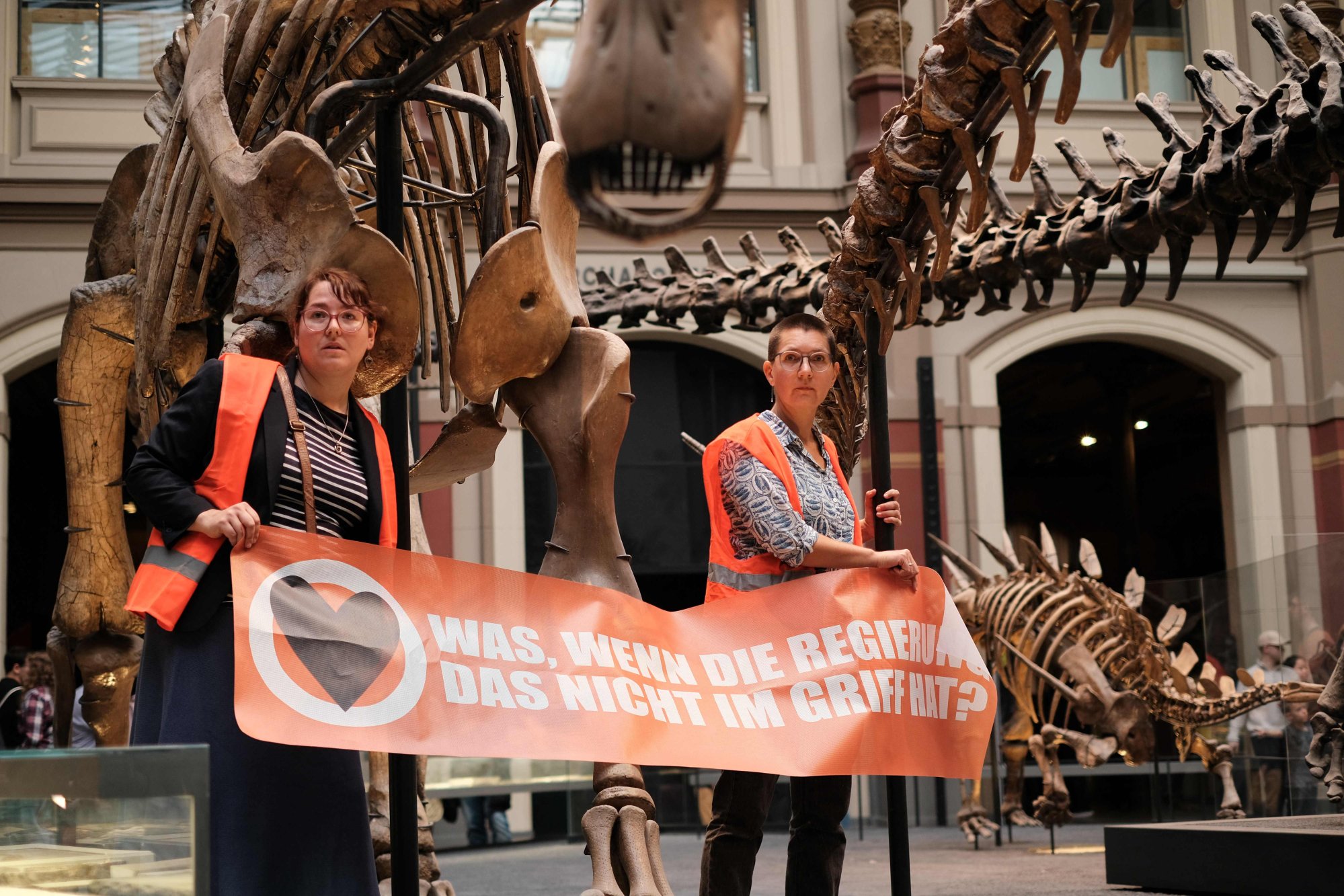 Climate activists from the group Last Generation hold a banner reading “what if the government does not have it under control?” in Berlin’s Natural History Museum on Sunday. Photo: AFP