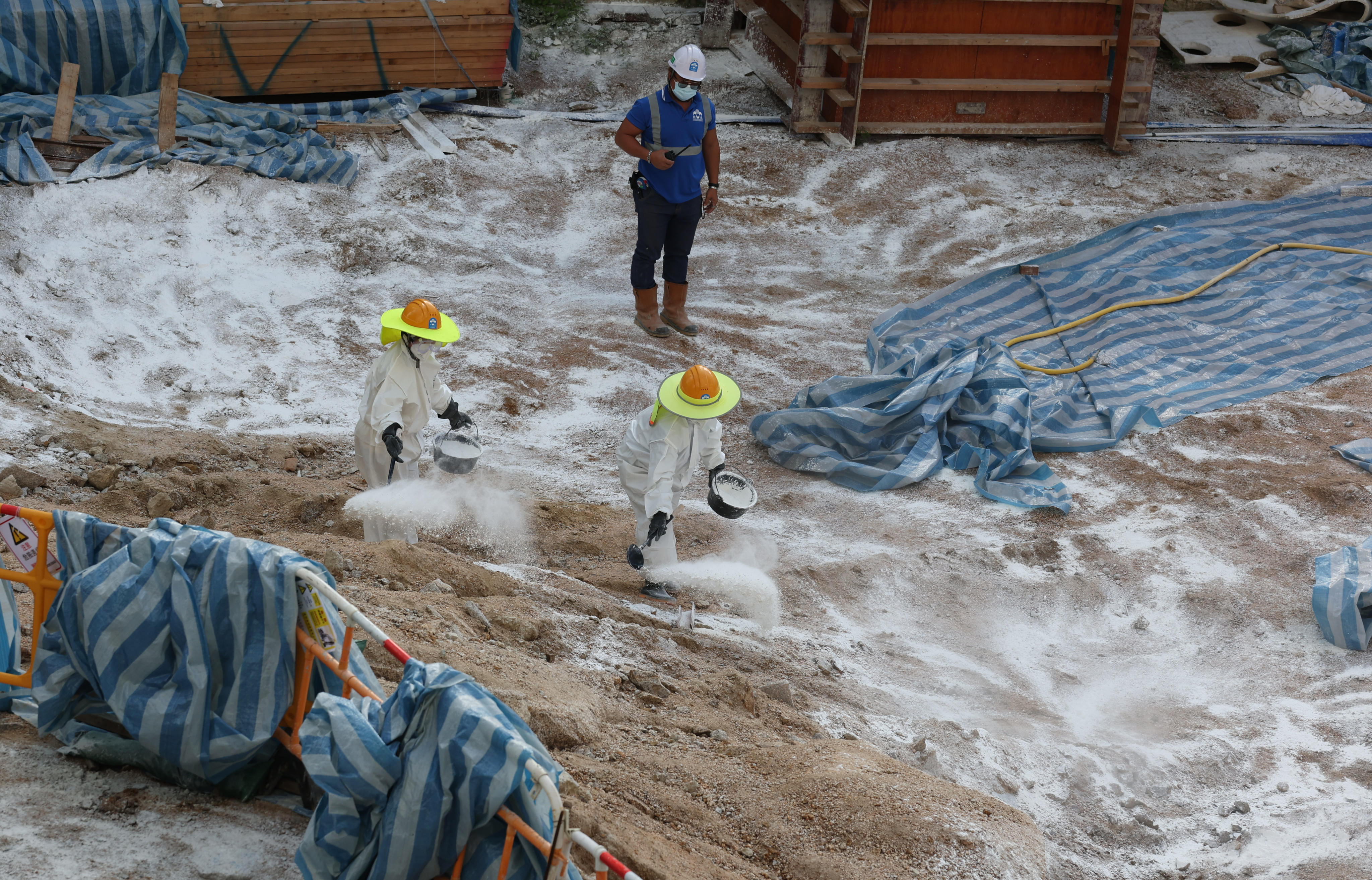 Workers sprayed disinfectant at a construction site in Pak Tin Estate, Sham Shui Po, after four soil samples tested positive for the bacterium that causes melioidosis. Photo: Yik Yeung-man