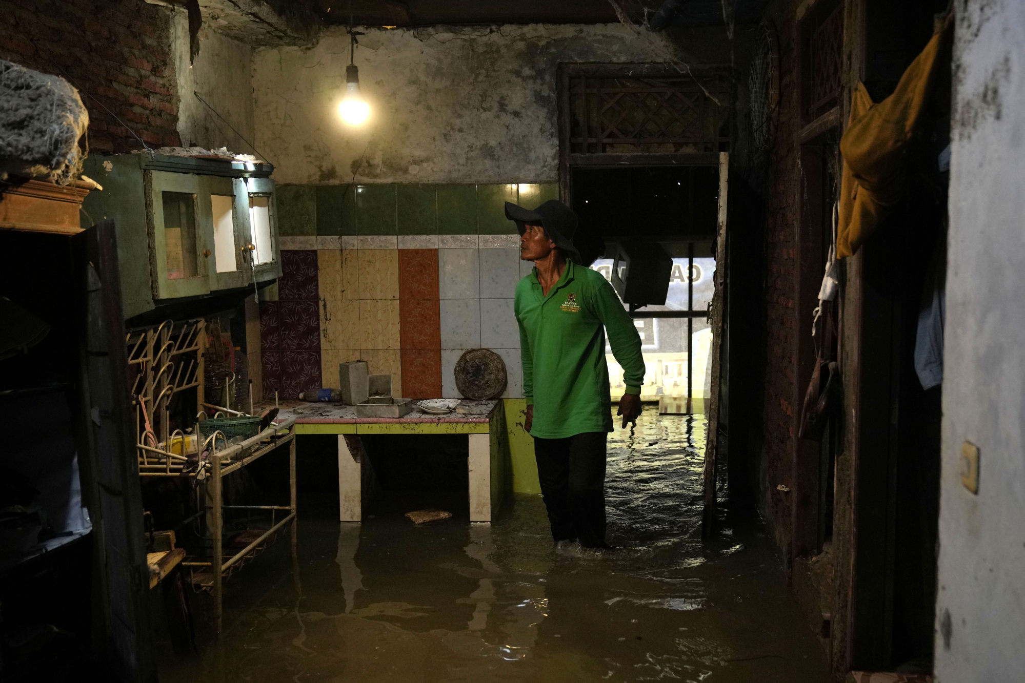 A man visits the home he abandoned two years ago in Mondoliko, Central Java. Poor and vulnerable communities are most affected by climate change and adaptation efforts should address the related losses and damage they suffer. Photo: AP