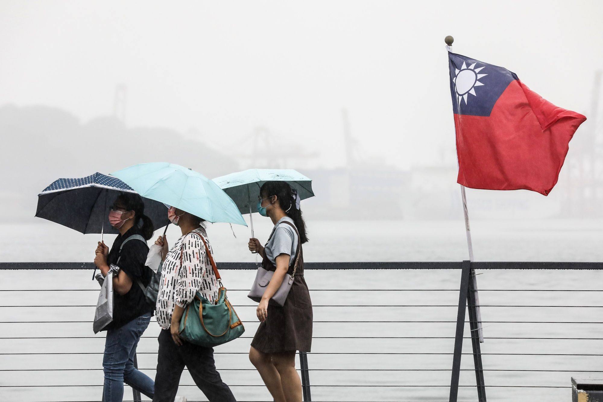 People walk by a Taiwanese flag in Keelung, Taiwan, on October 10 as the island marks the foundation of the Republic of China. Over the years, Beijing has promoted both social and economic integration with Taiwan to push for unification. Photo: Bloomberg
