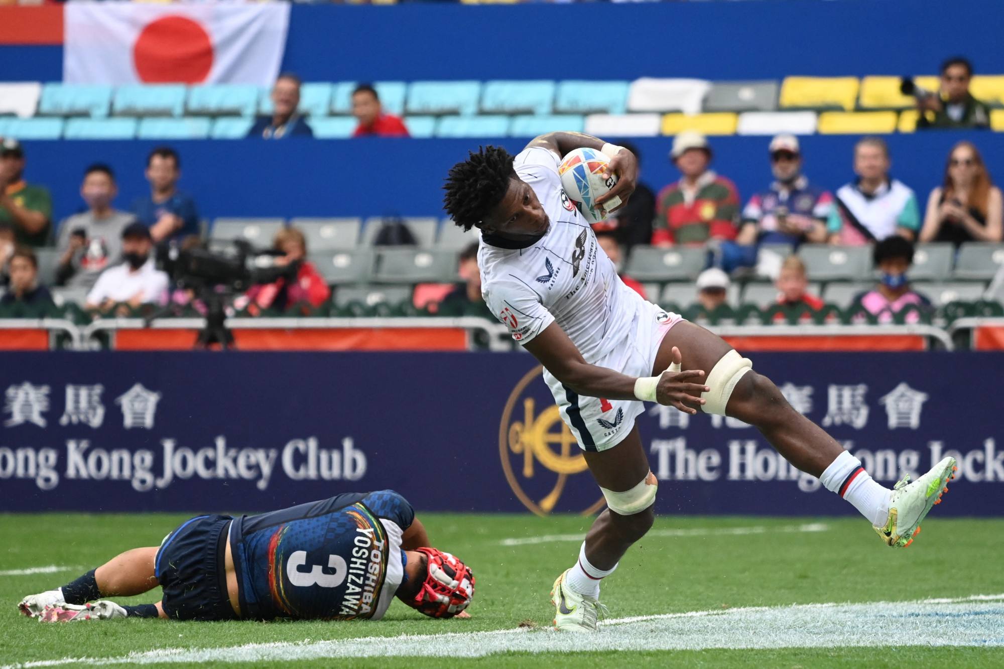 Aaron Cummings of the US scores a try after Japan’s Taichi Yoshizawa misses a tackle. Photo: AFP
