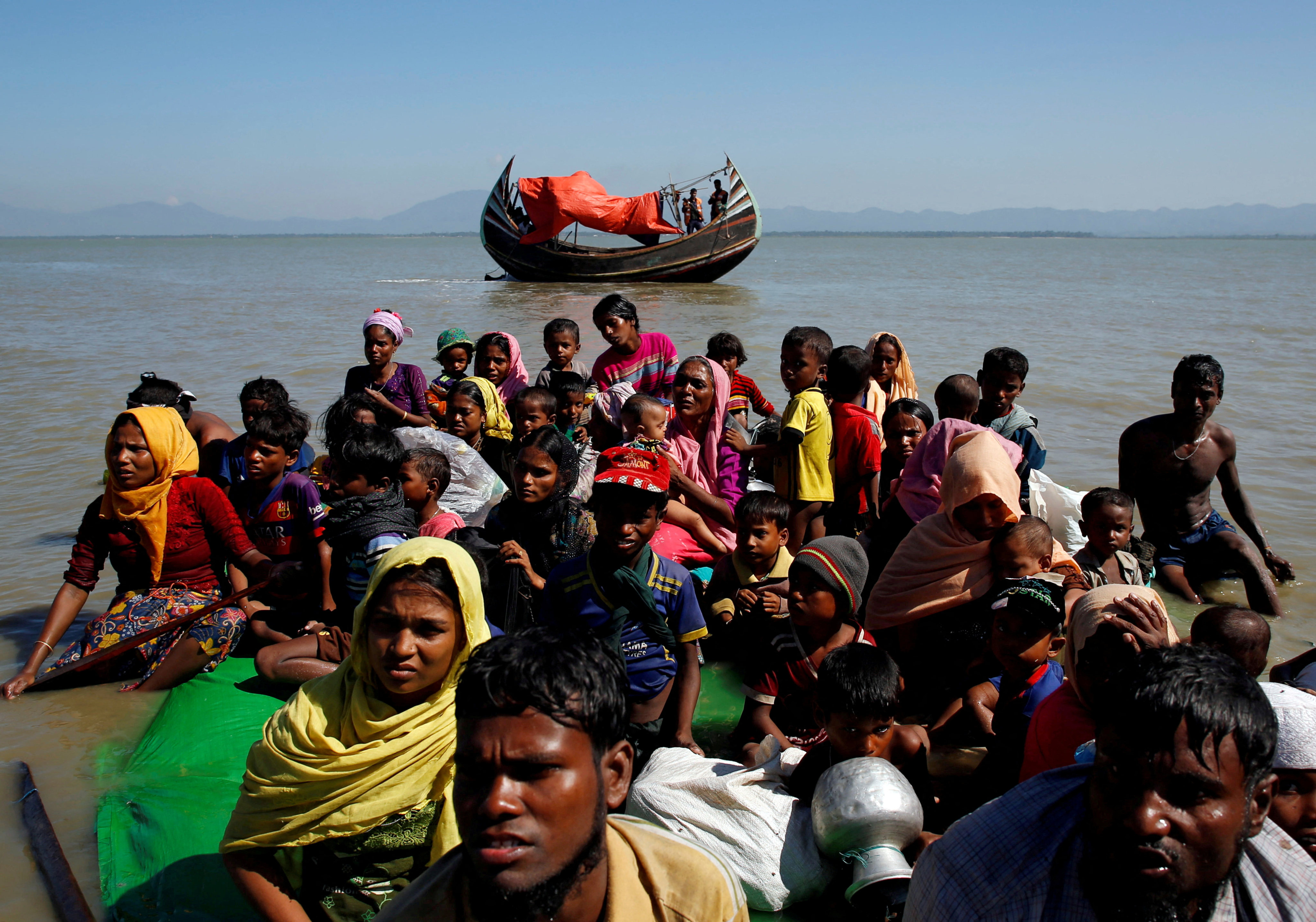 Rohingya refugees sit on a makeshift boat after crossing the Bangladesh-Myanmar border in 2017. Photo: Reuters